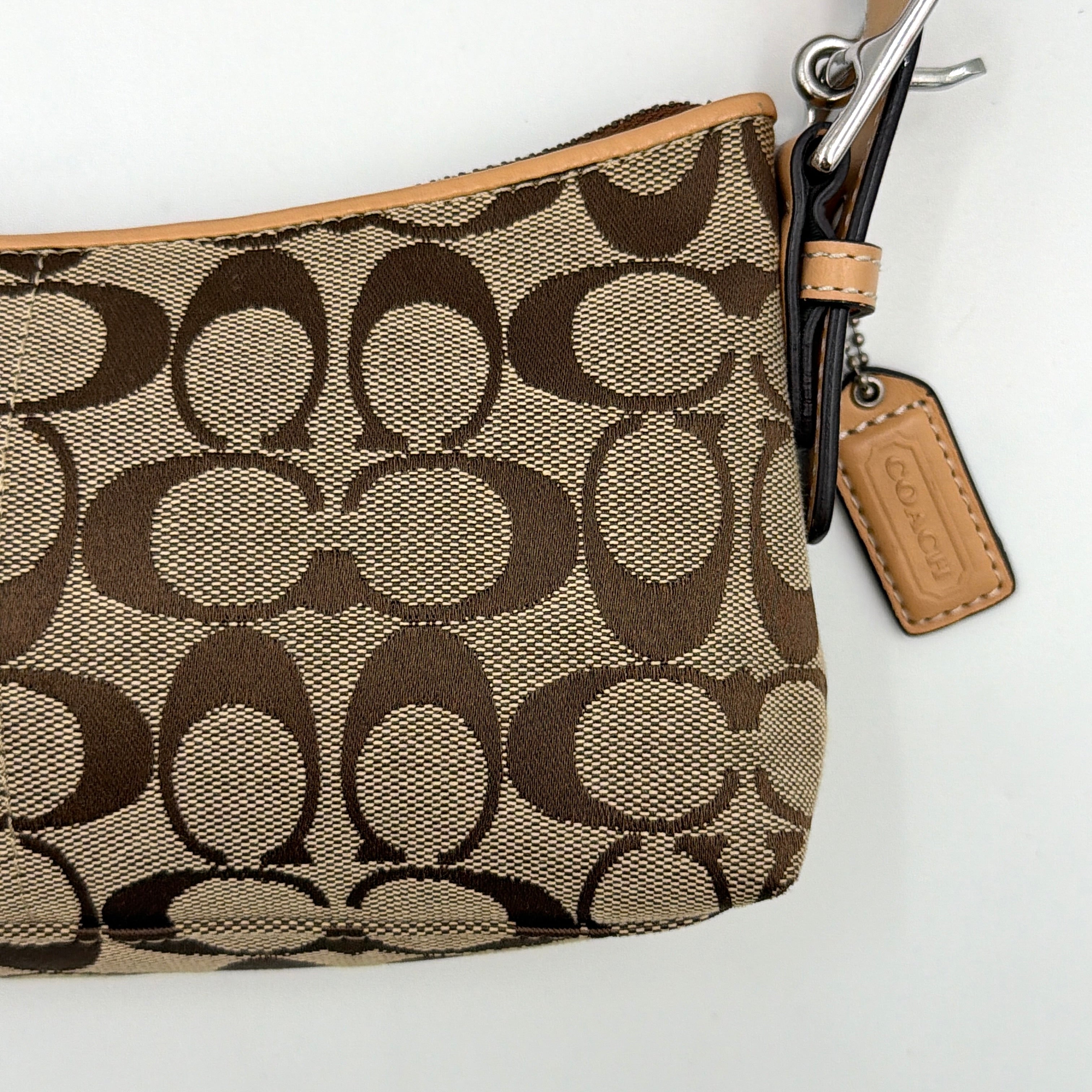 Coach Hamptons Demi Baguette shoulder bag in beige monogram canvas with tan leather trim and silver hardware.
