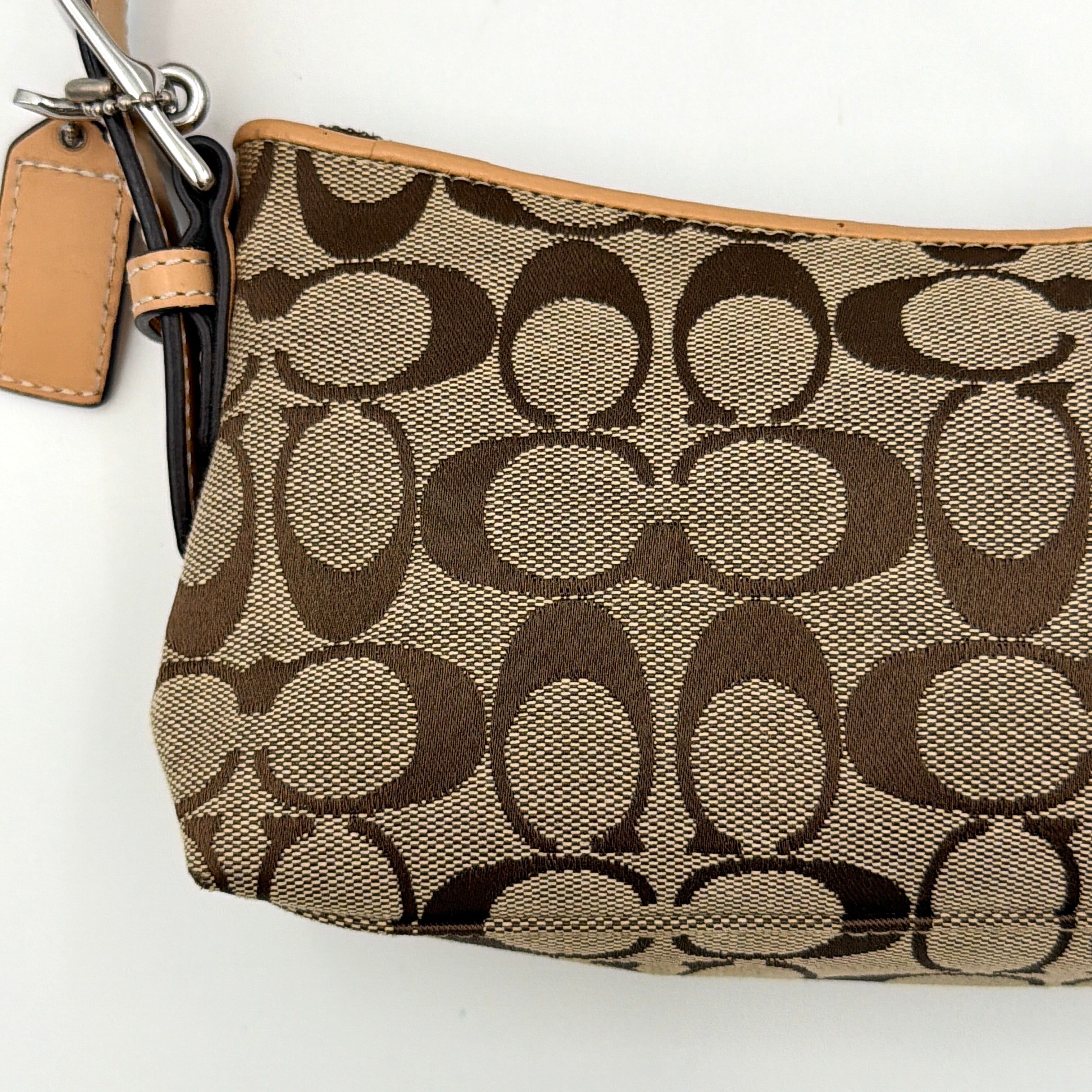 Coach Hamptons Demi Baguette shoulder bag in beige monogram canvas with tan leather trim and silver hardware.