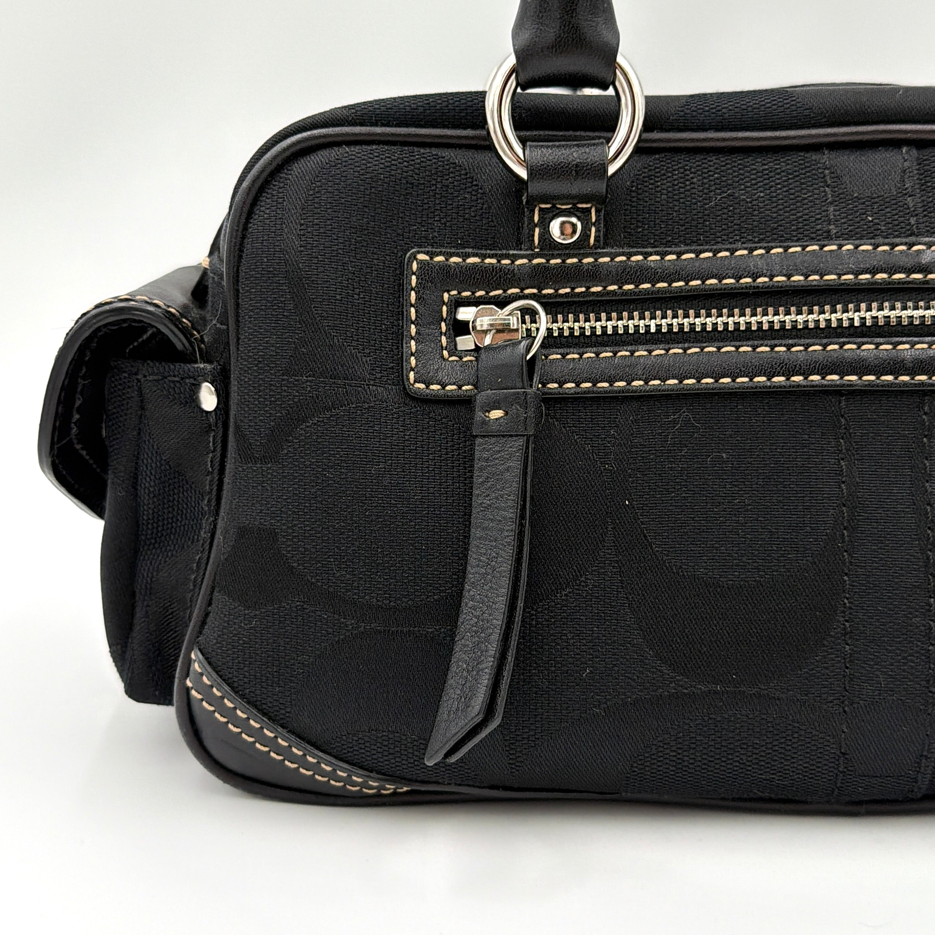 Coach black Signature Gallery satchel with double handles and silver hardware, set against a clean background.