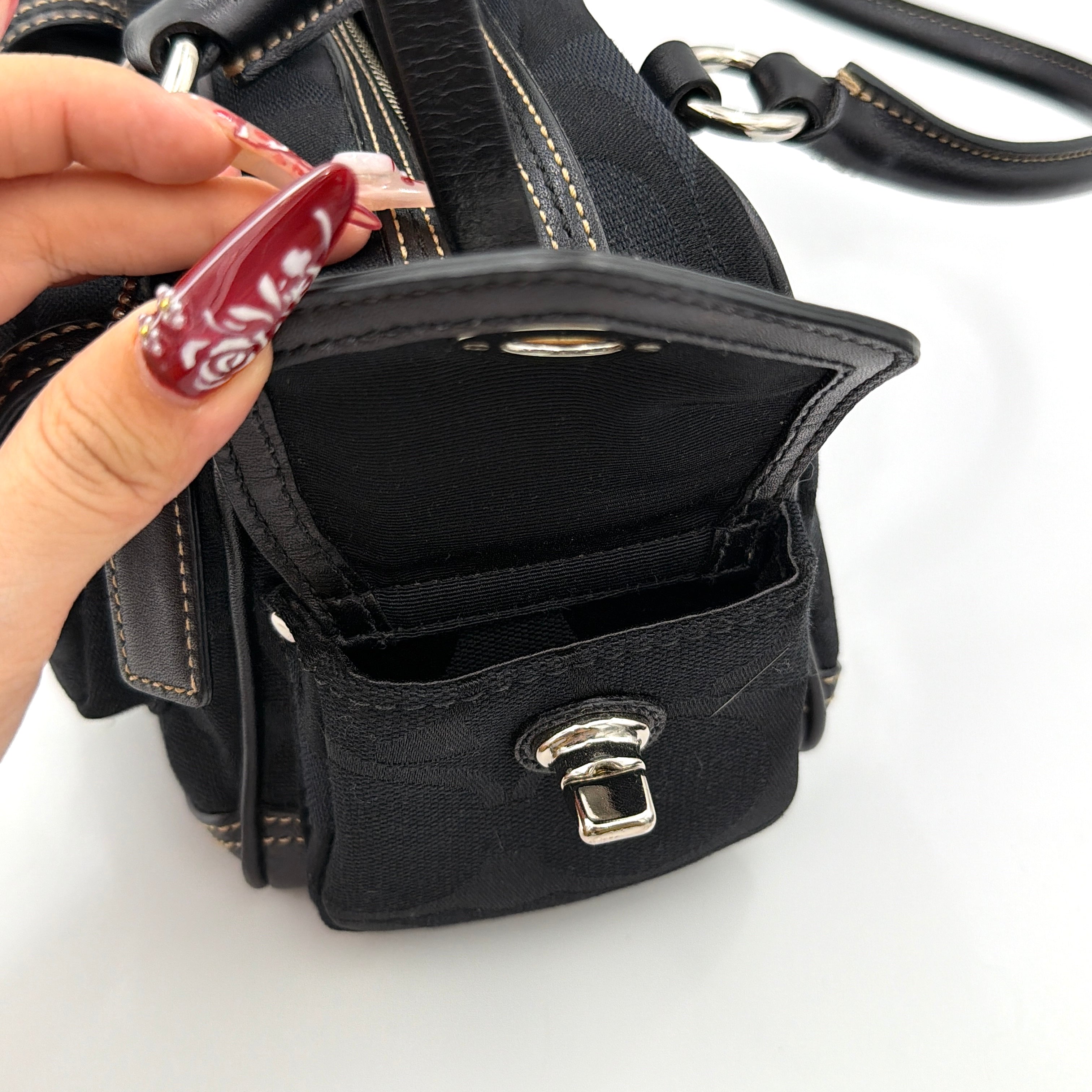 Coach black Signature Gallery satchel with double handles and silver hardware, set against a clean background.
