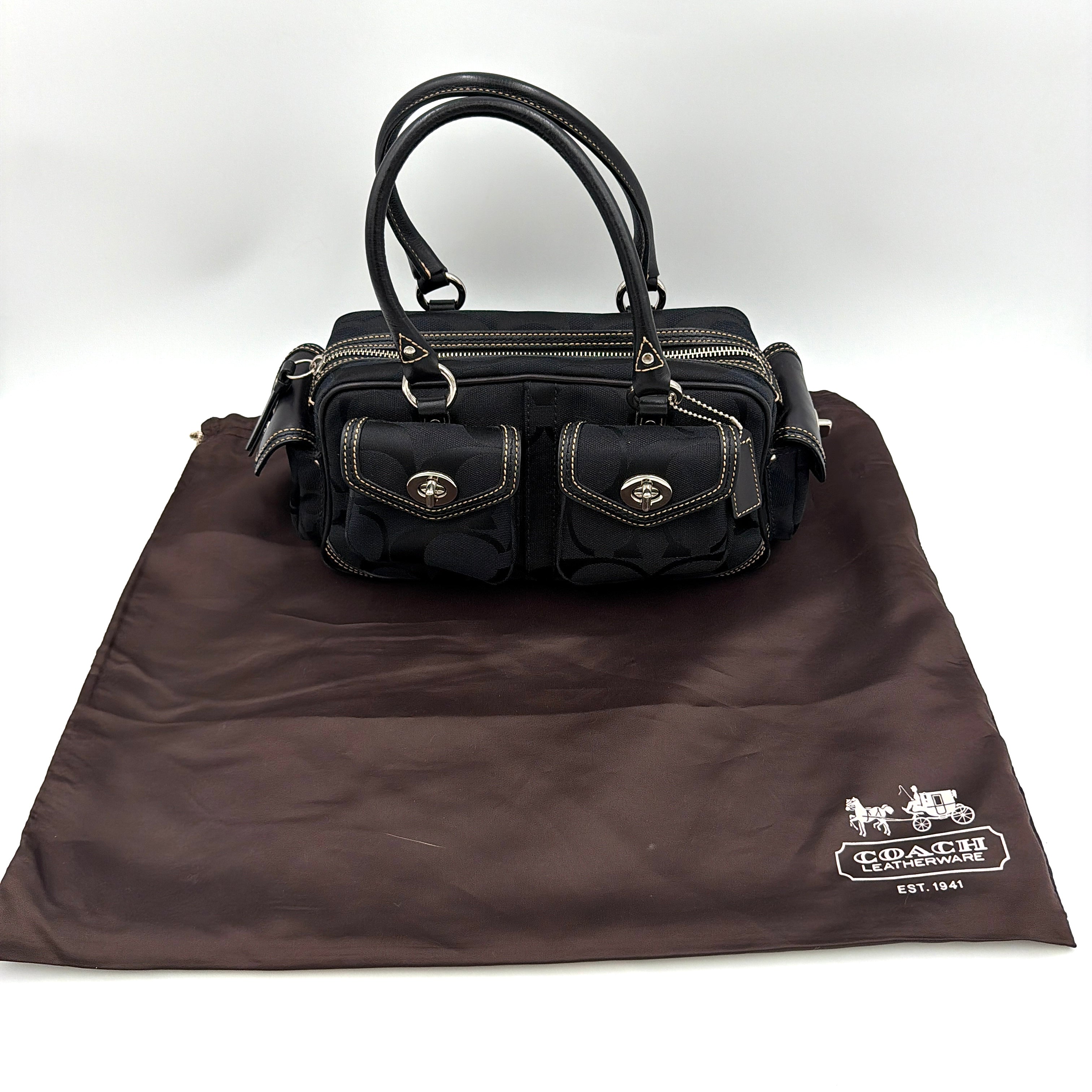 Coach black Signature Gallery satchel with double handles and silver hardware, set against a clean background.