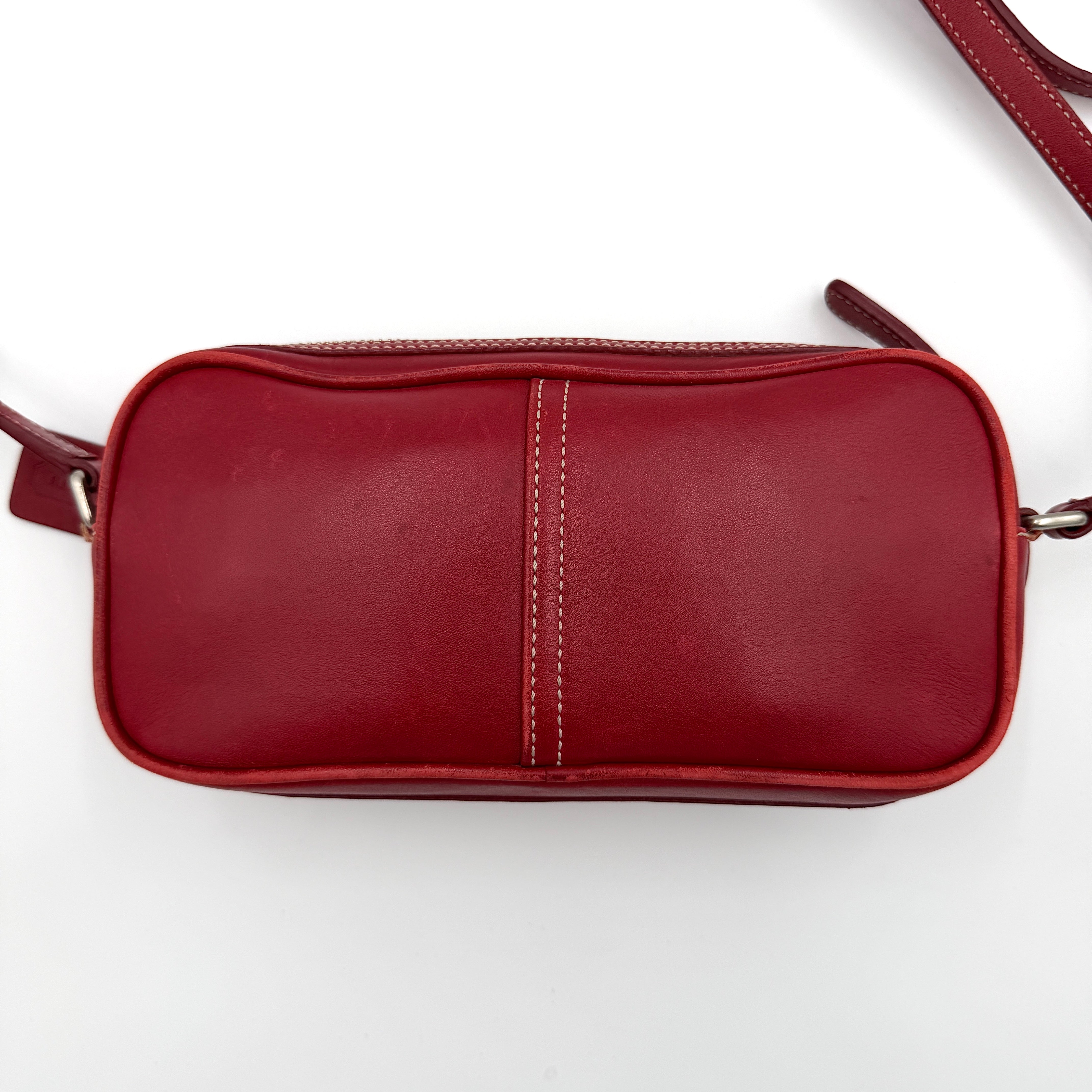 Burgundy Coach Legacy West Crossbody Camera Bag with contrast stitching, exterior zip pocket, and slender adjustable strap.