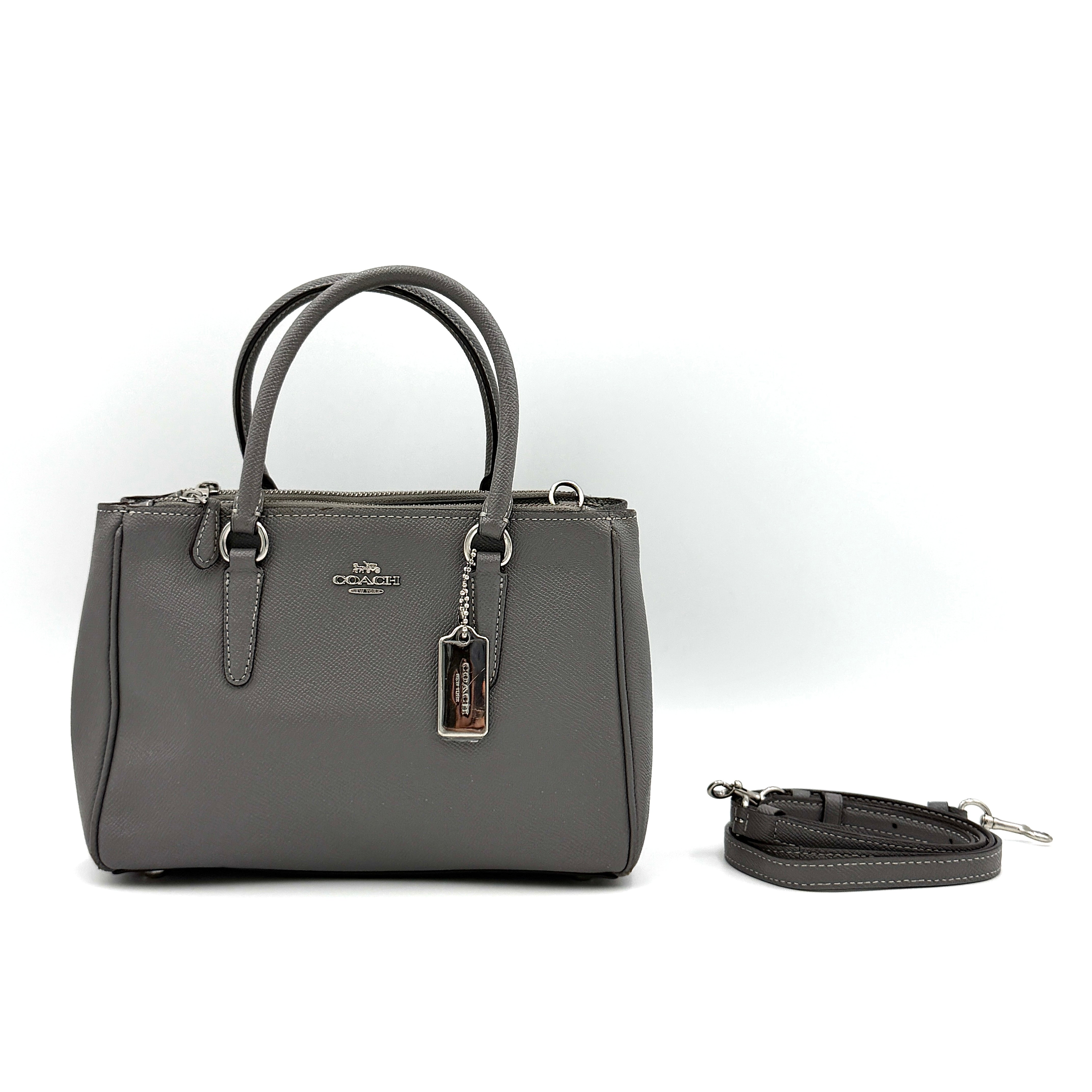 Coach 2Way Mini Surrey Carryall Handbag in grey textured leather with top handles and detachable strap, styled against a clean background.