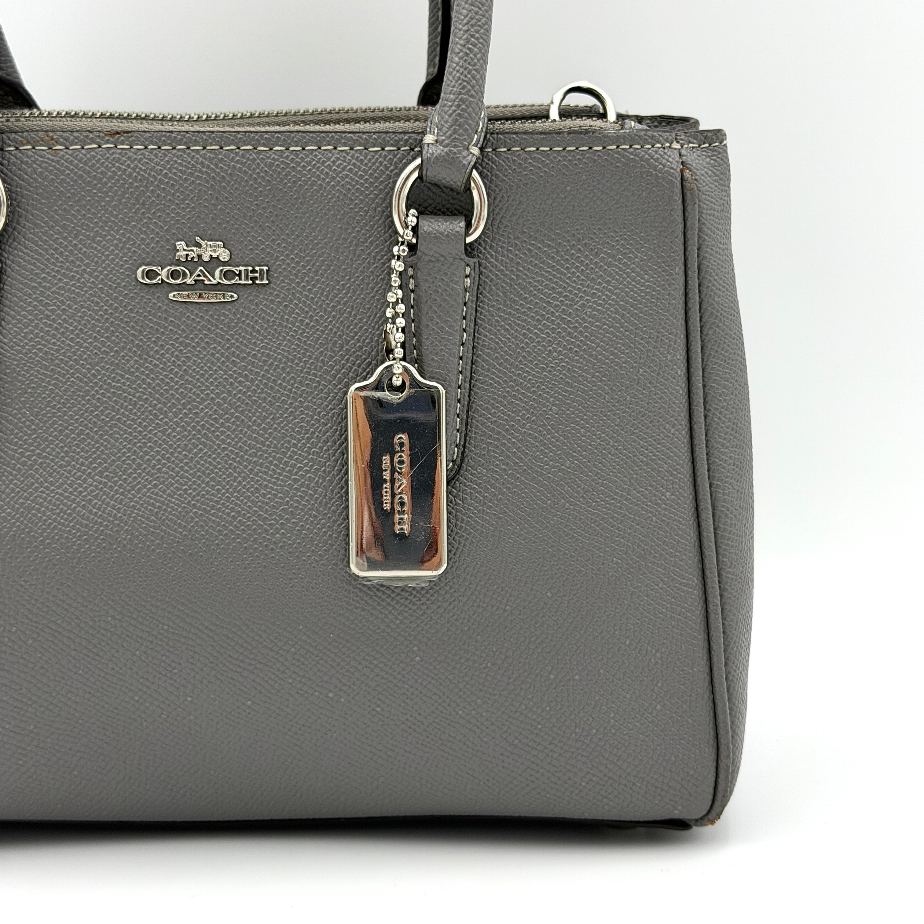 Coach 2Way Mini Surrey Carryall Handbag in grey textured leather with top handles and detachable strap, styled against a clean background.