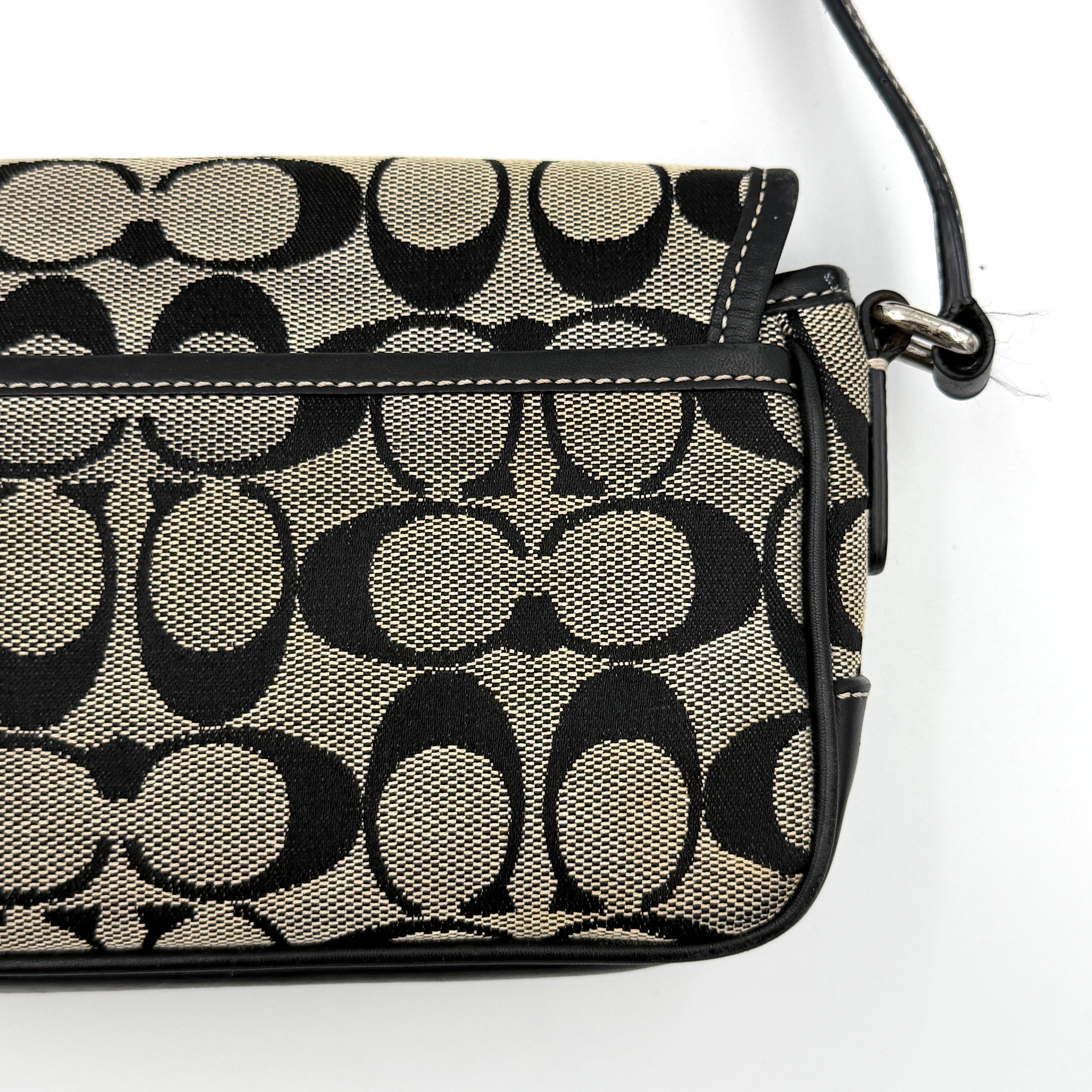 Coach Signature Double Buckle Crossbody bag in grey and black jacquard canvas, accented with black leather trim and dual silver-tone buckle detailing.