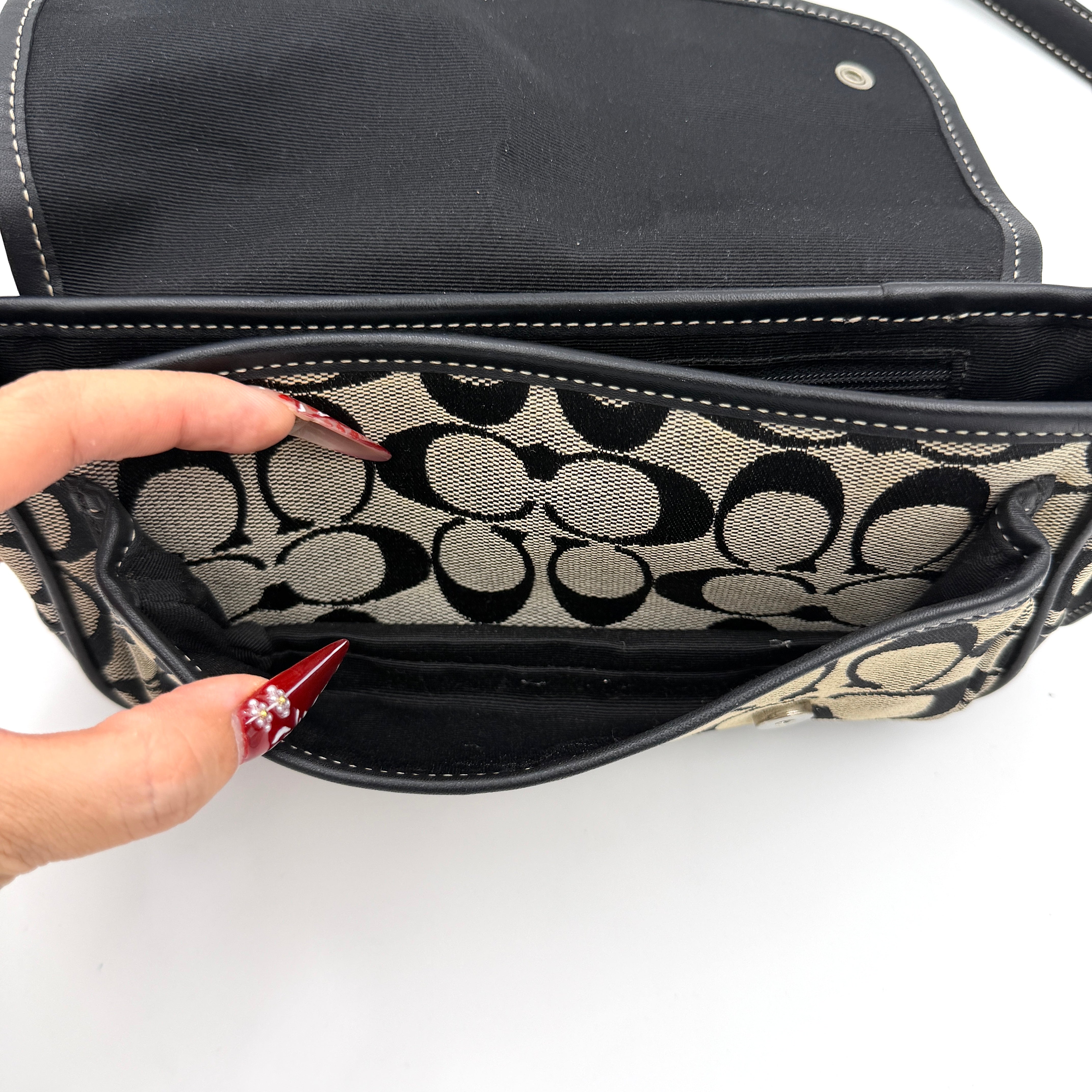 Coach Signature Double Buckle Crossbody bag in grey and black jacquard canvas, accented with black leather trim and dual silver-tone buckle detailing.