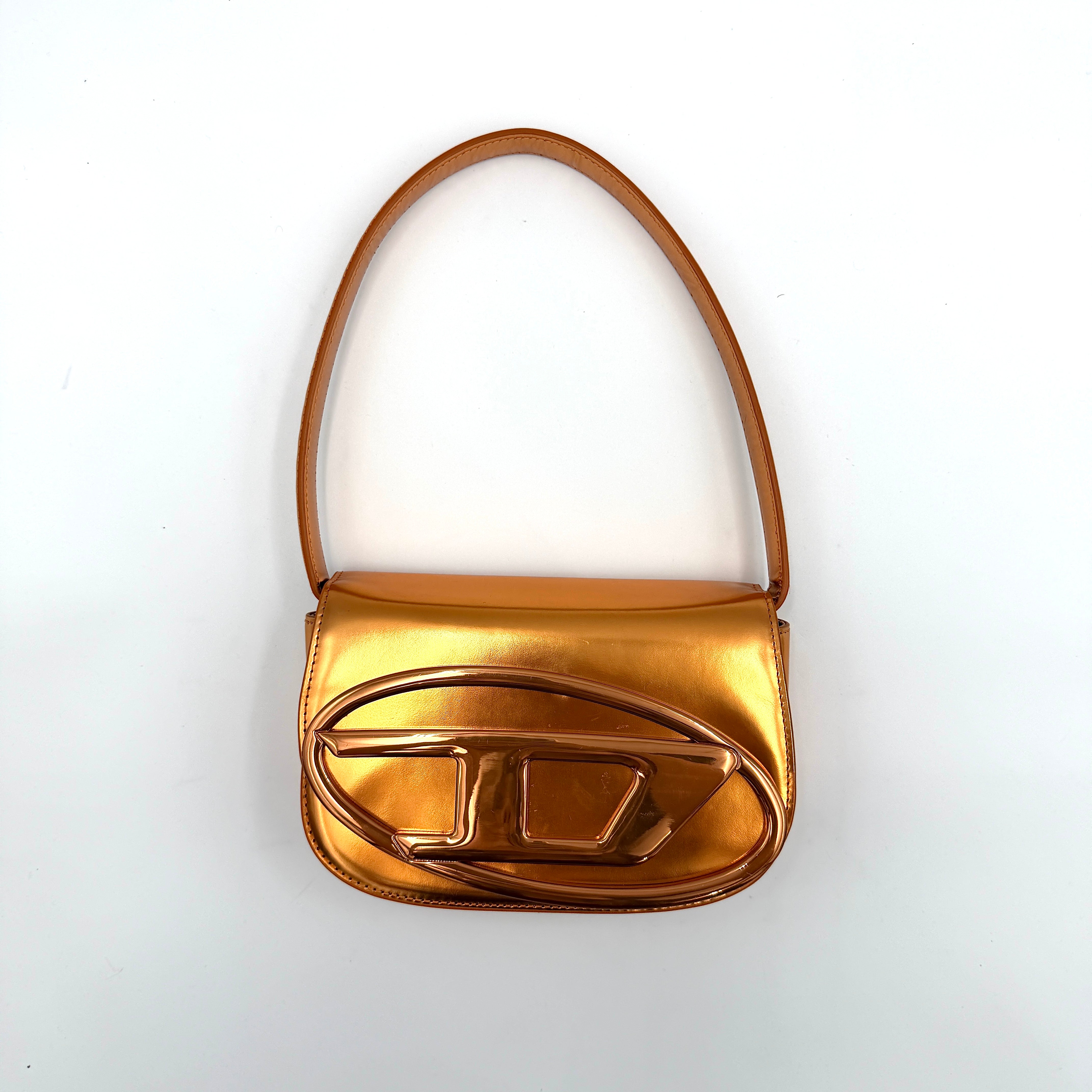 A Diesel 2Way 1DR Shoulder Bag in striking metallic gold with an embossed logo and detachable strap, displayed alongside its accessories.