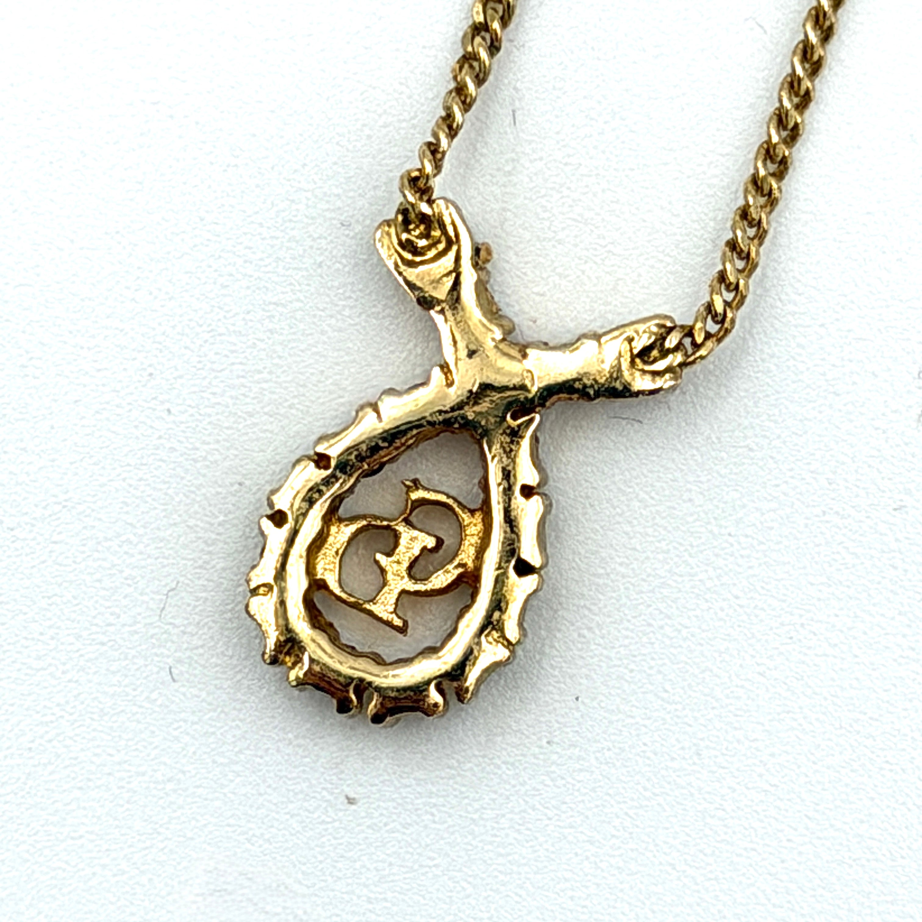 Dior CD Logo Rhinestone Necklace in gold featuring a teardrop pendant adorned with clear rhinestones and a gold chain.
