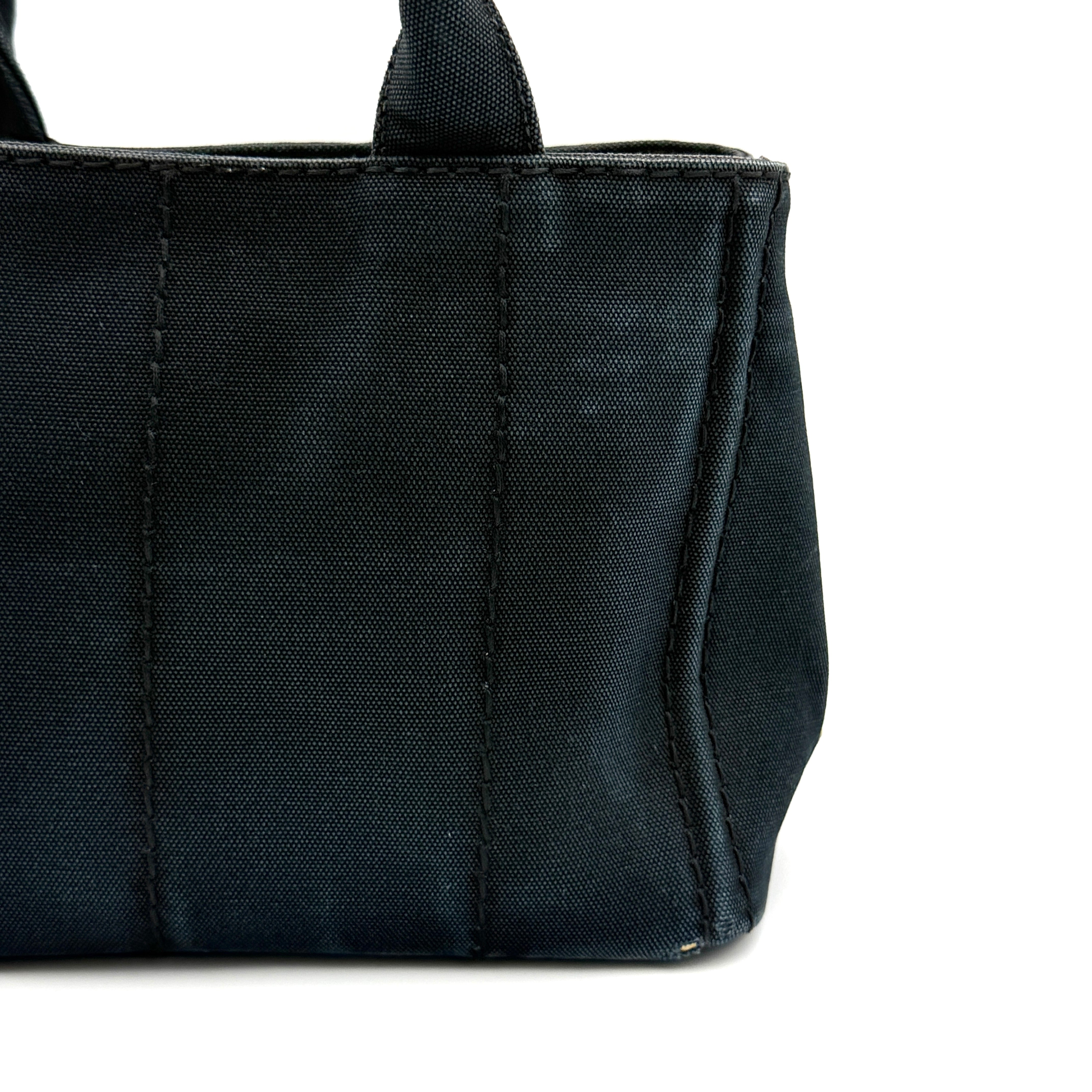 Front-facing Prada Canapa Embroidered Logo Tote in black canvas with ivory stitched logo and double handles.