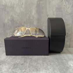 Prada Transparent Silver Vintage Sunglasses with a sleek titanium frame and clear gradient lenses, featuring an engraved Prada logo on the temples.