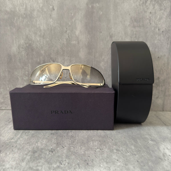Prada Transparent Silver Vintage Sunglasses with a sleek titanium frame and clear gradient lenses, featuring an engraved Prada logo on the temples.