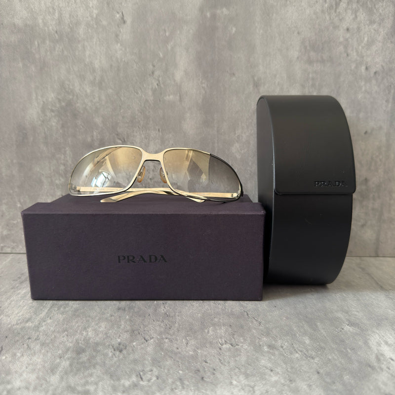 Prada Transparent Silver Vintage Sunglasses with a sleek titanium frame and clear gradient lenses, featuring an engraved Prada logo on the temples.
