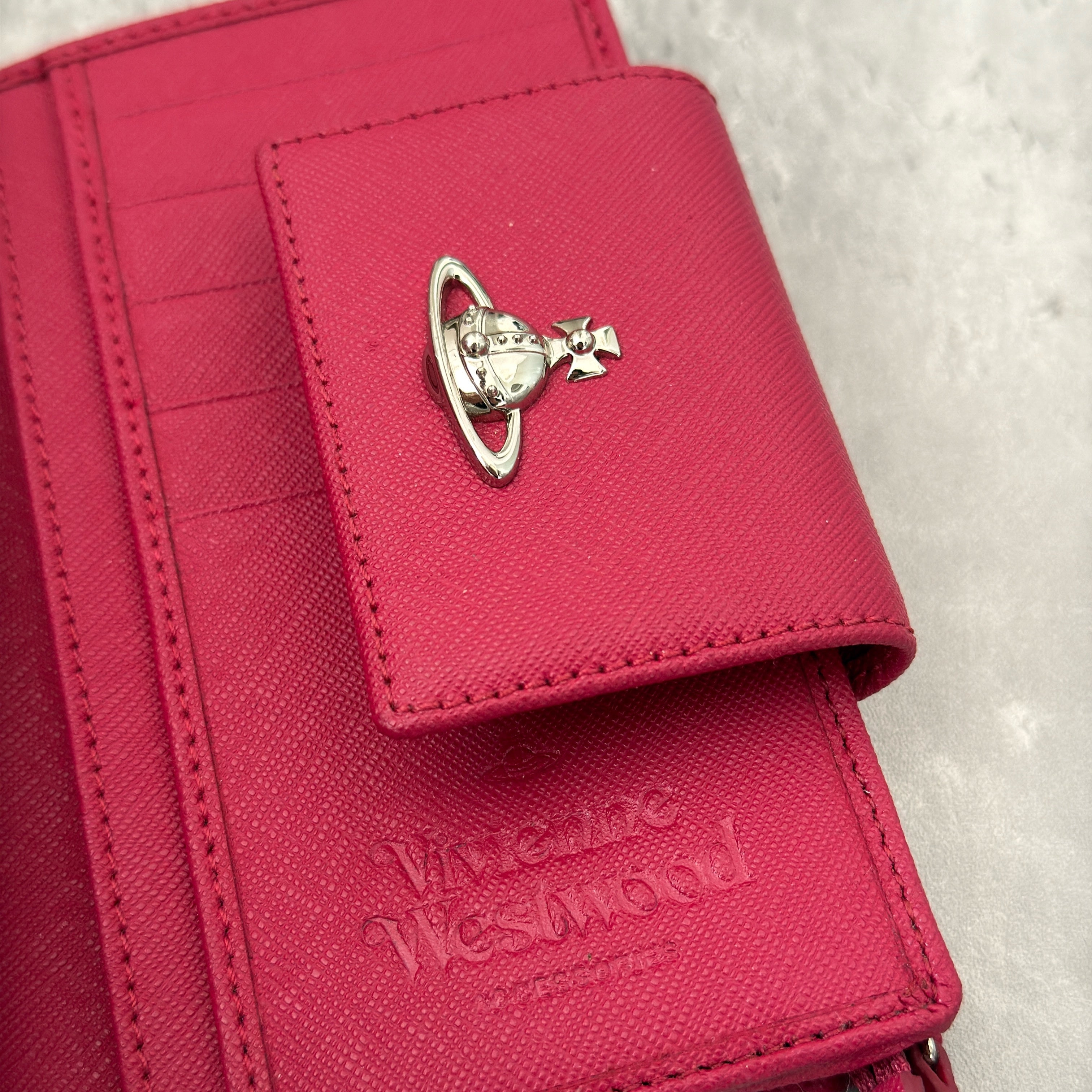 Vivienne Westwood Logo Orb Clip Wallet in Rose Pink Saffiano Leather with silver-tone emblem, card slots, and zippered coin pouch.