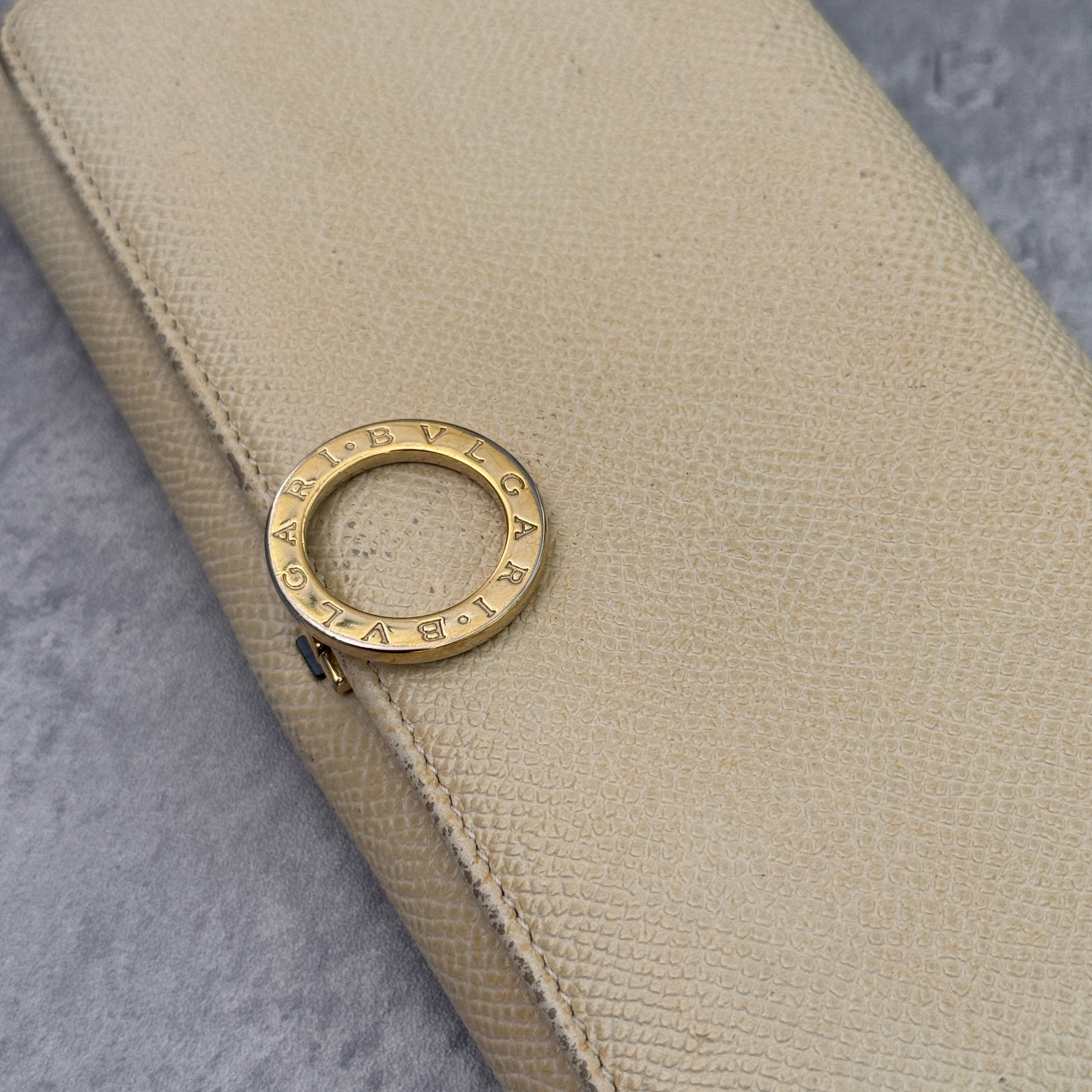 Bvlgari B.Zero1 Beige Saffiano Leather Long Wallet featuring a gold-tone ring clasp and fuchsia pink leather interior.