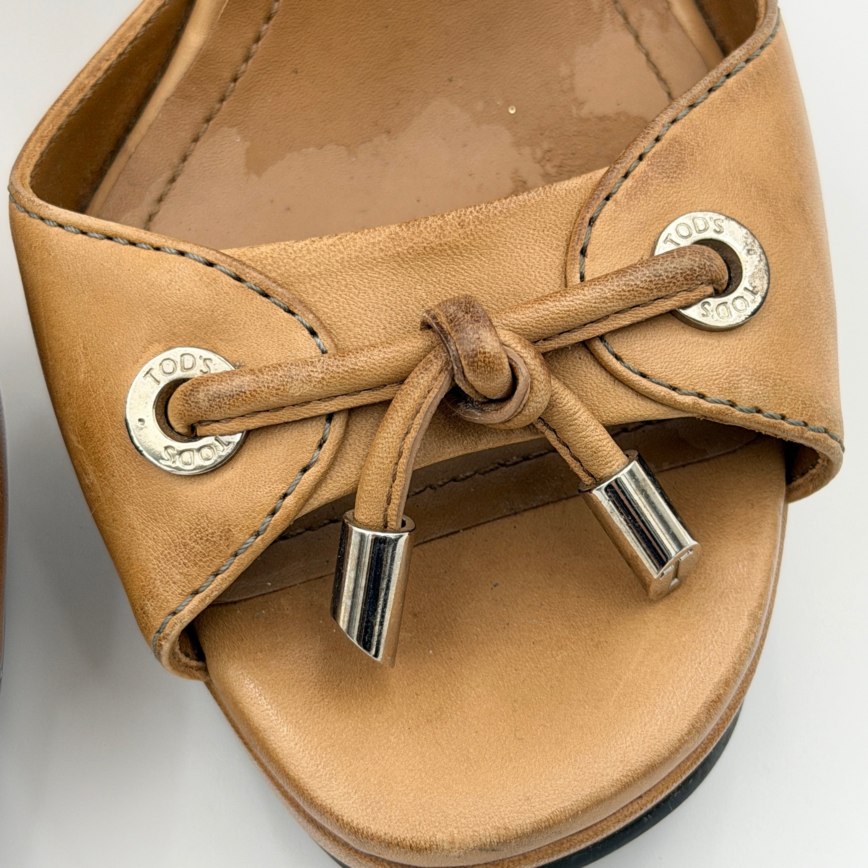 Tan leather Tod's peep-toe platform wedge sandals with ankle strap and front bow detail, shown from an angle.