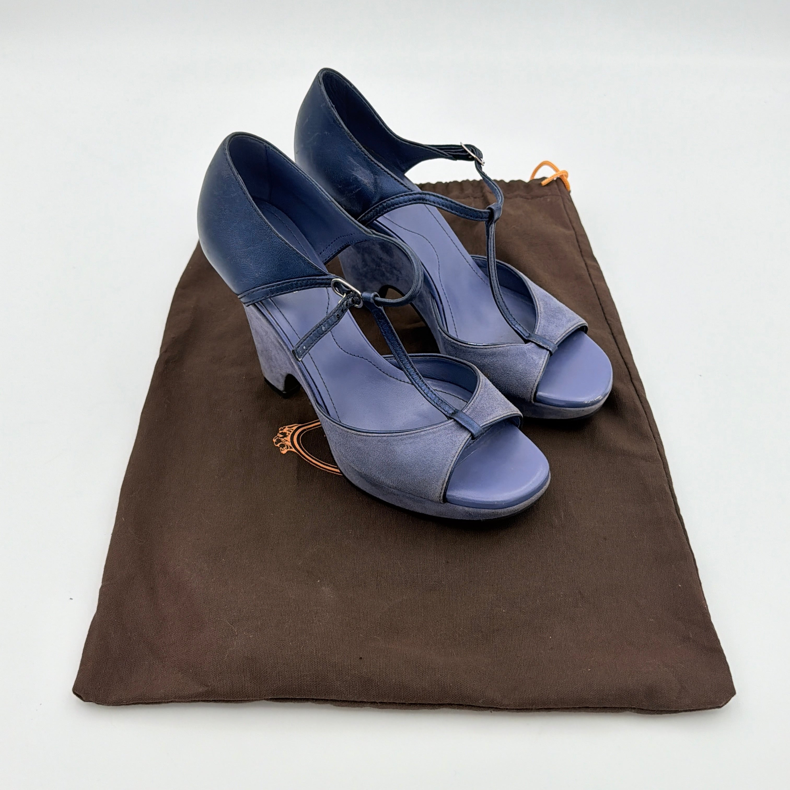 A pair of Tod's blue suede and leather T-strap platform wedge sandals with buckle detail, displayed at an angle.