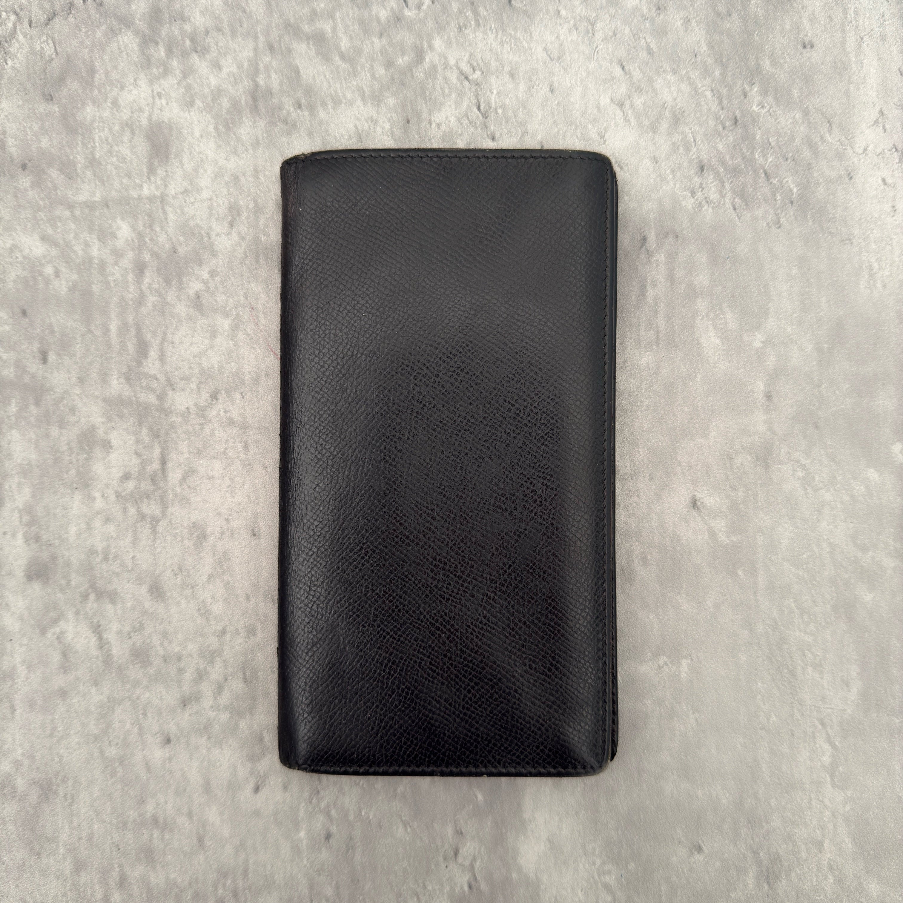Bvlgari Bi-Fold Leather Black Long Wallet, crafted from textured black leather with multiple card slots and bill compartments for organization.