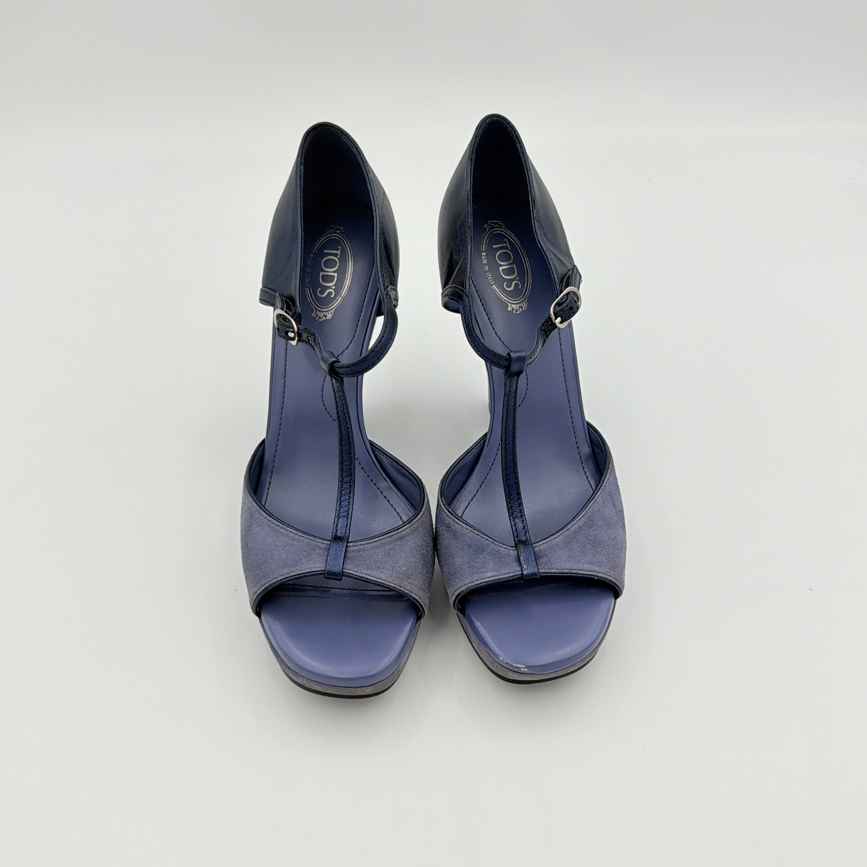A pair of Tod's blue suede and leather T-strap platform wedge sandals with buckle detail, displayed at an angle.