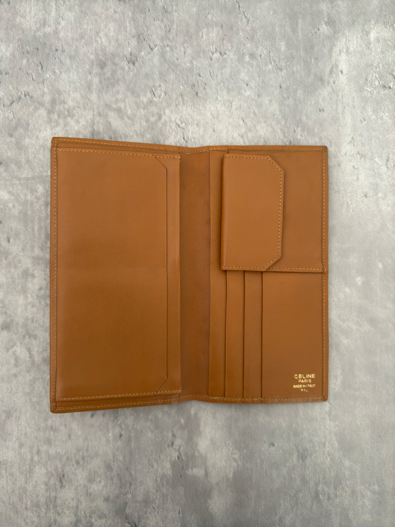 Celine Macadam Triomphe Canvas Long Wallet in brown monogram canvas with tan leather trim, featuring a bifold design with multiple compartments and a snap-button coin pocket.