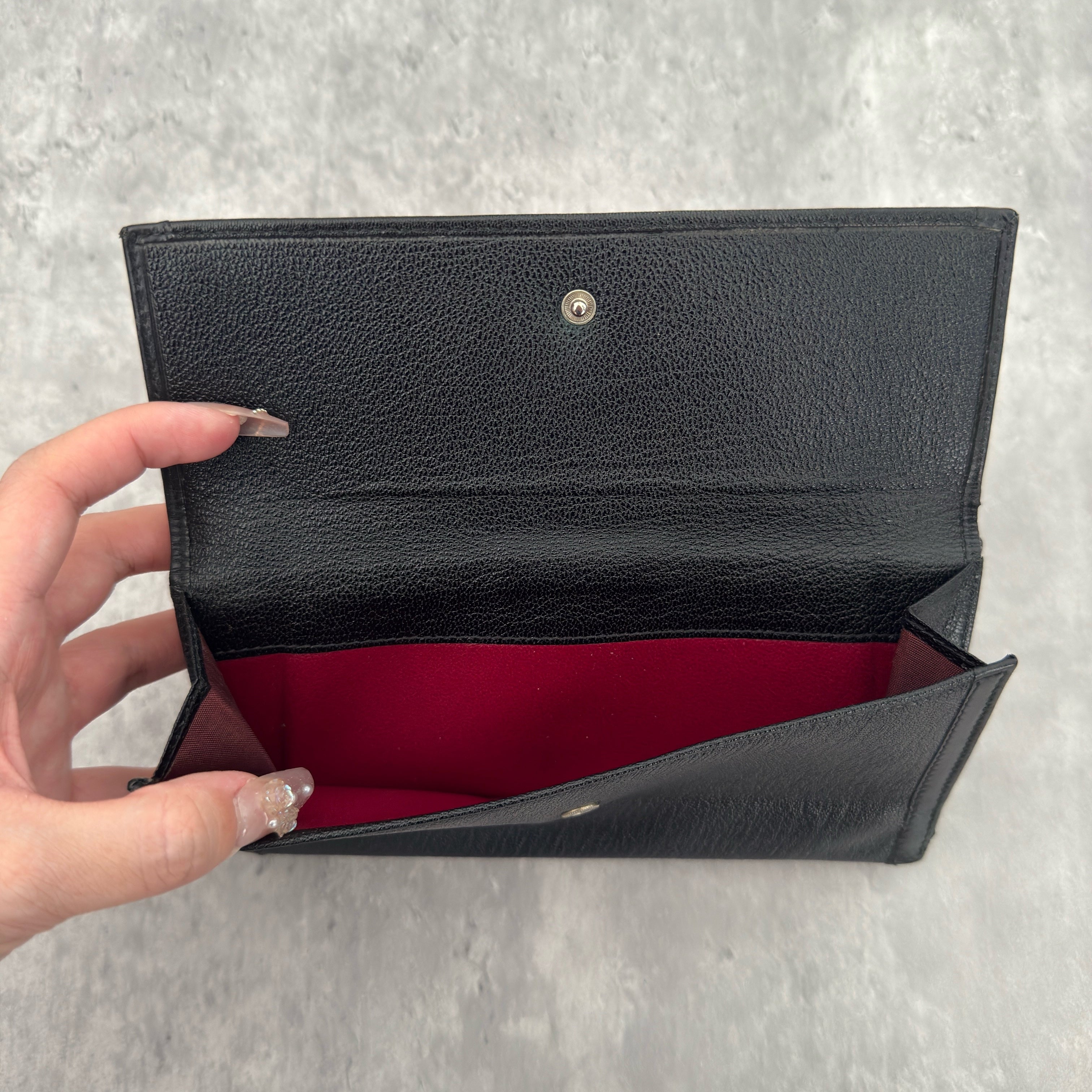 Bvlgari Doppio Tondo Bifold Long Wallet in black leather, featuring a silver-tone logo clasp, red fabric interior, and multiple compartments.