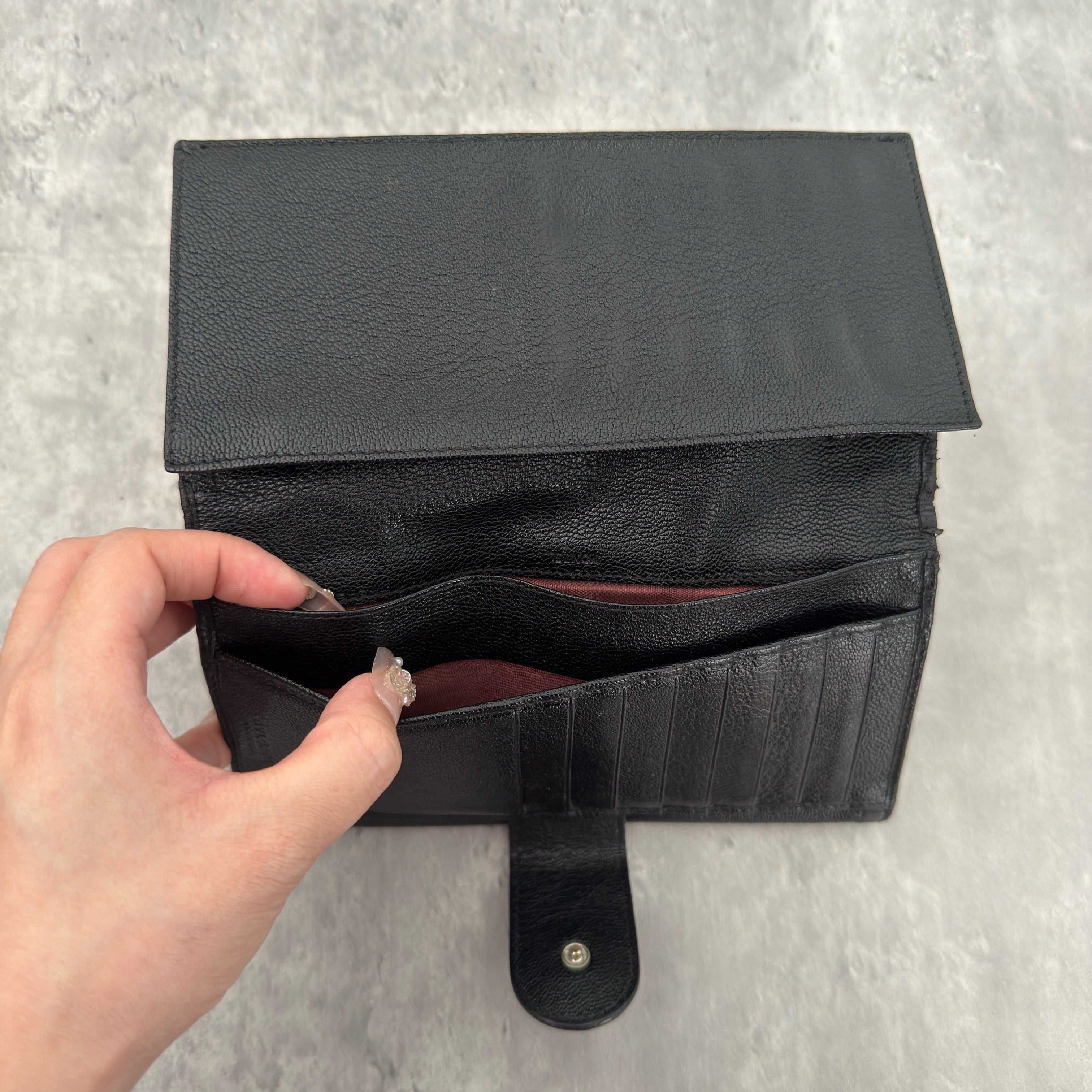 Bvlgari Doppio Tondo Bifold Long Wallet in black leather, featuring a silver-tone logo clasp, red fabric interior, and multiple compartments.