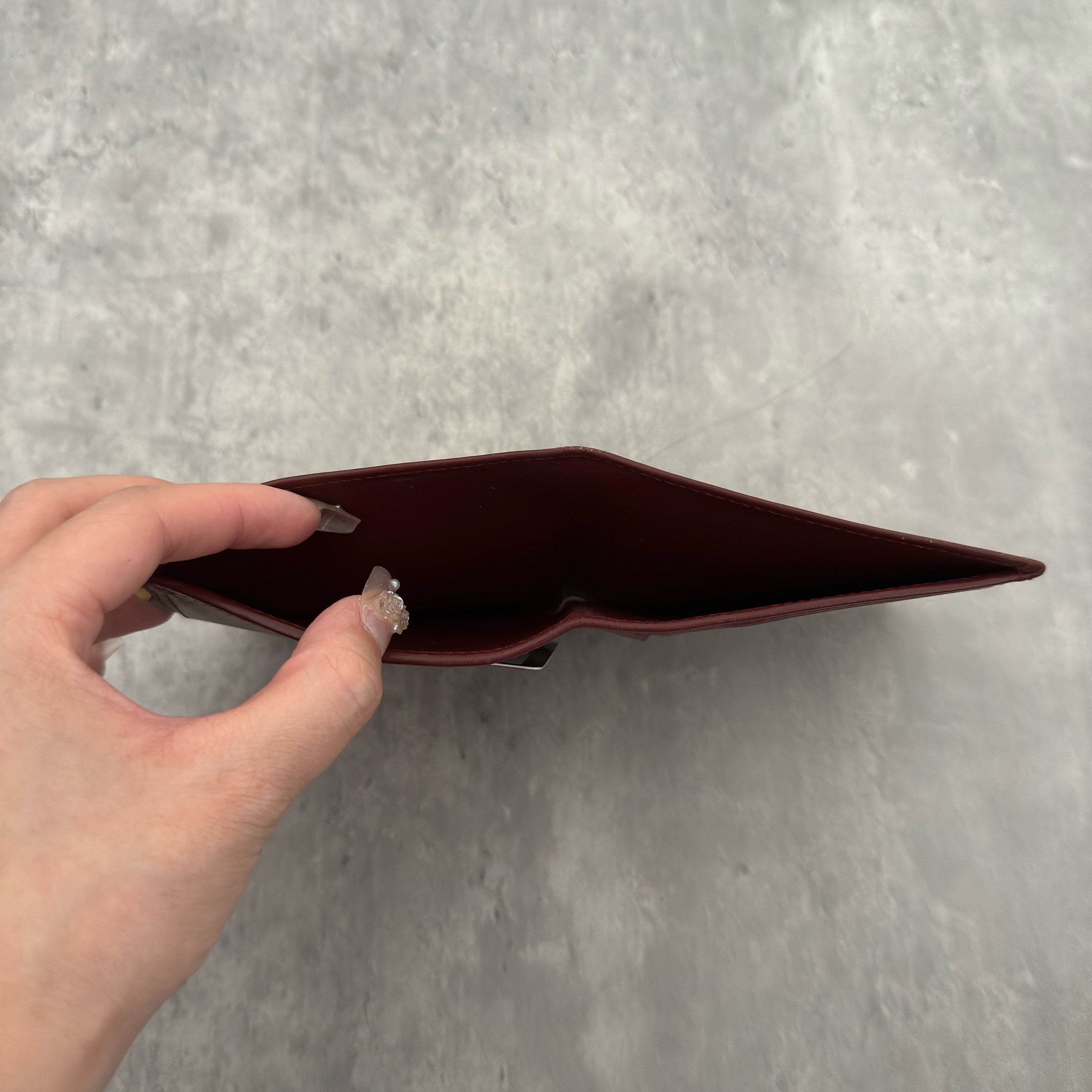 Cartier Mast Line Bordeaux Burgundy Wallet in premium leather, featuring gold-tone corner accents and embossed logo.