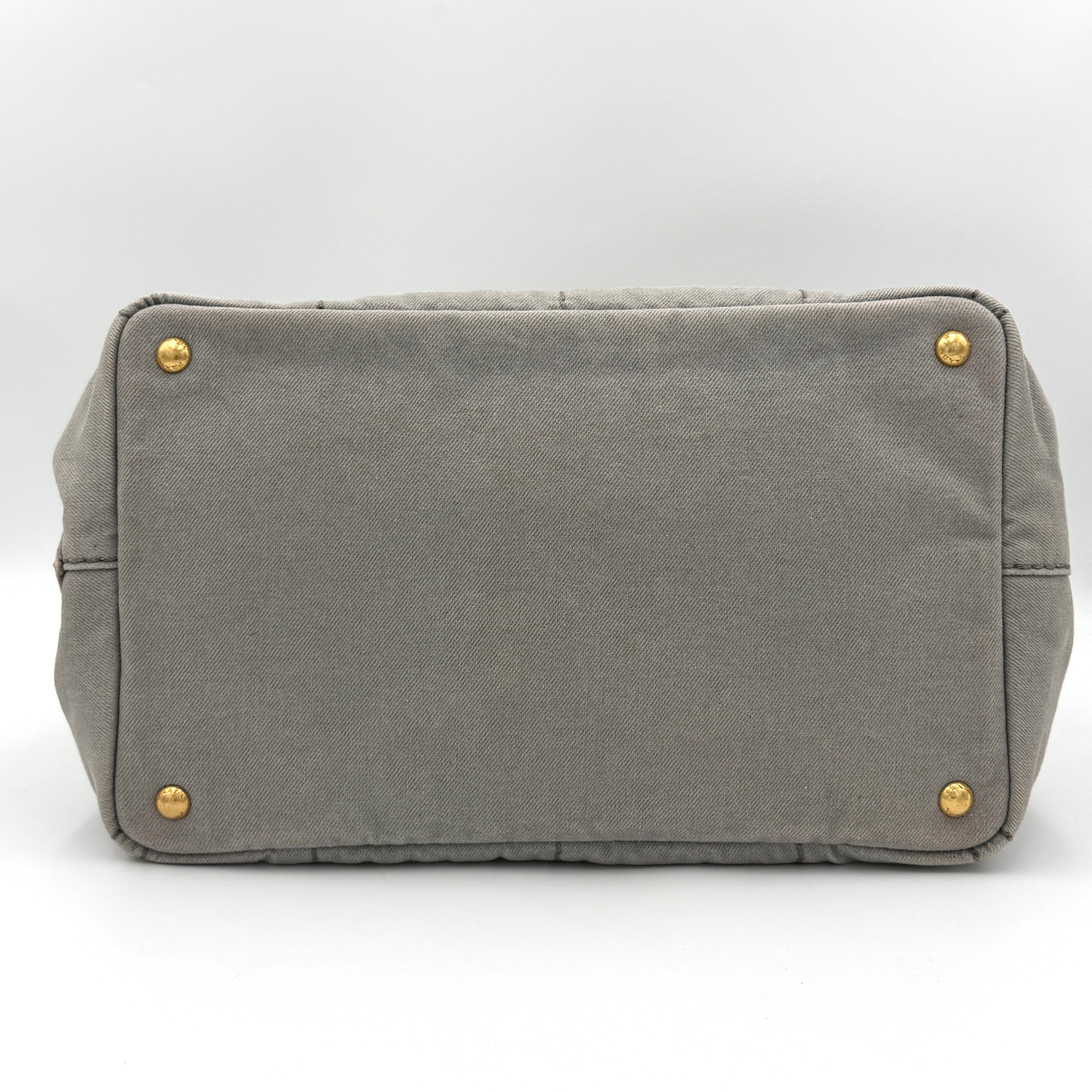 Prada Canapa Tote Bag in grey canvas with rope logo motif and dual top handles against a plain background.