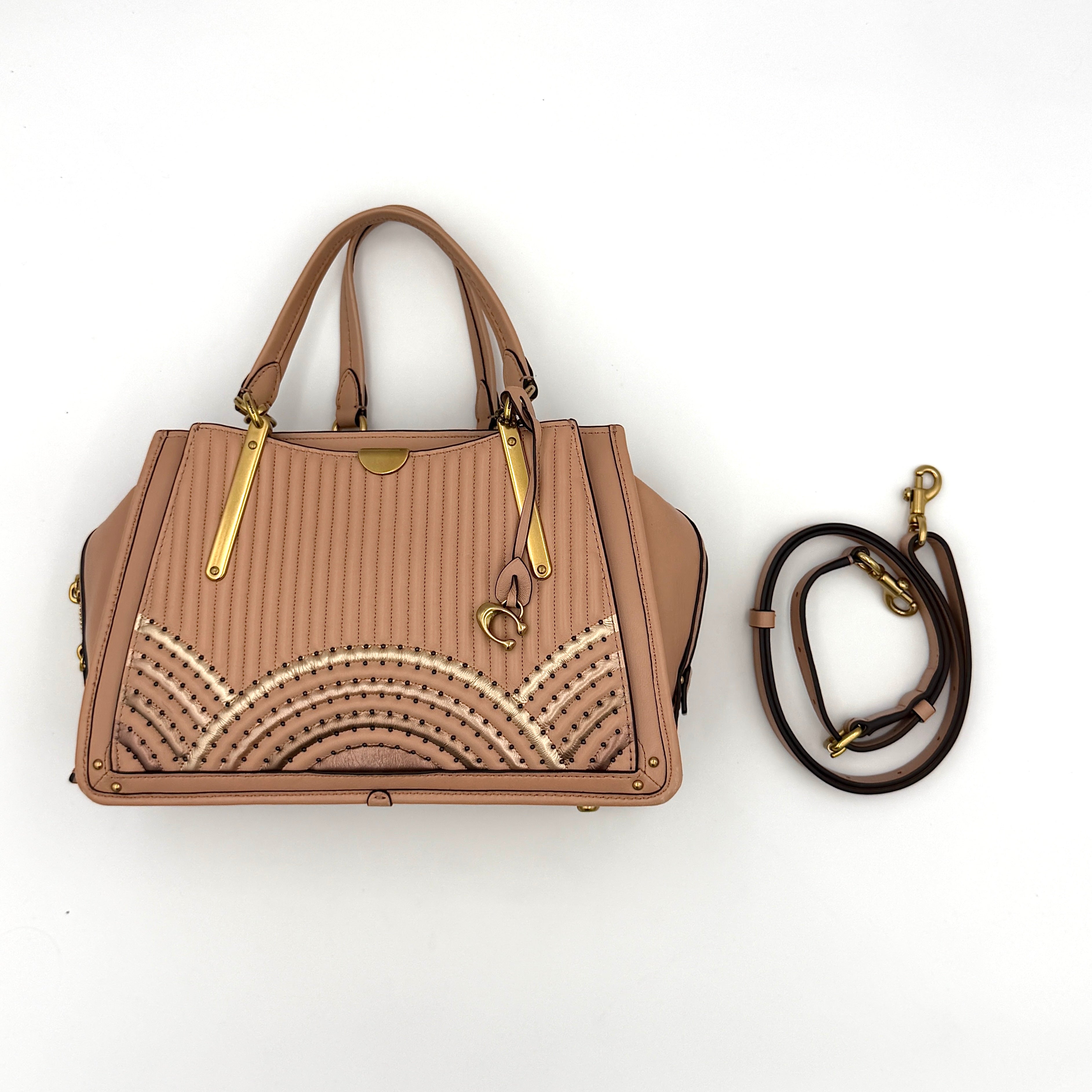 Coach Dreamer 27 handbag in nude pink leather with Deco quilting, gold rivets, and detachable strap, displayed elegantly on a plain background.
