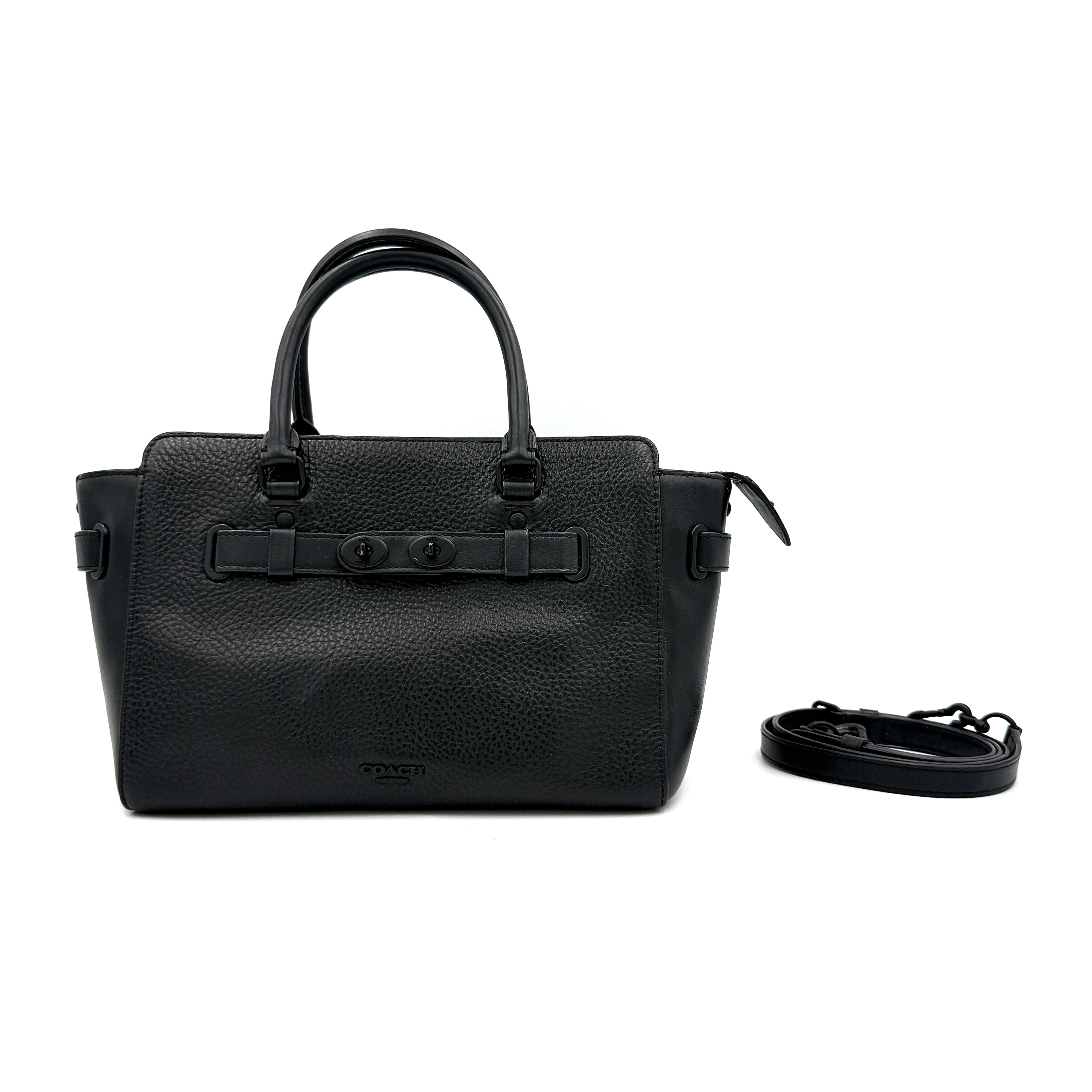 Coach Blake Carryall 25 bag in black pebbled leather with dual top handles, detachable strap, and front turnlock accents.