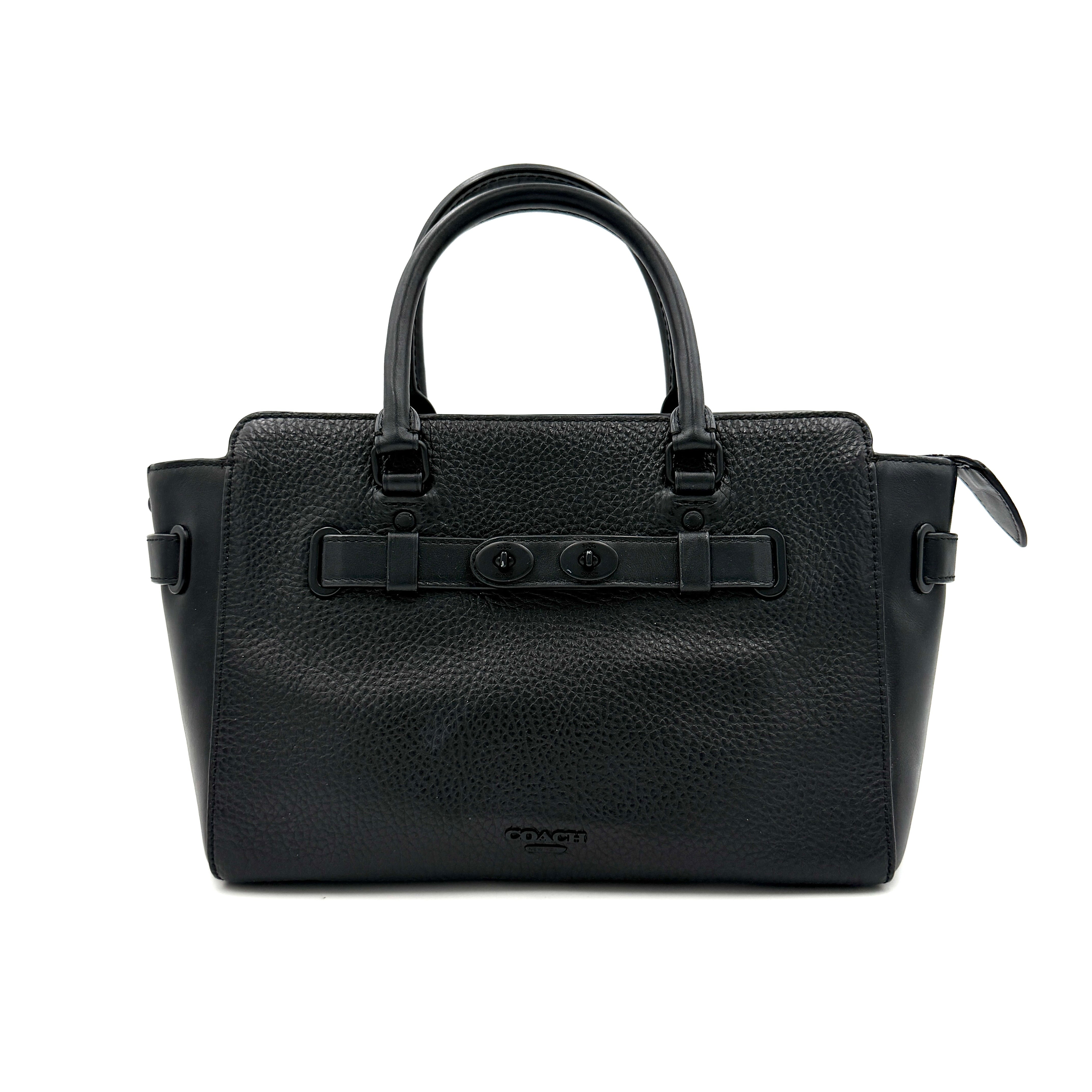 Coach Blake Carryall 25 bag in black pebbled leather with dual top handles, detachable strap, and front turnlock accents.