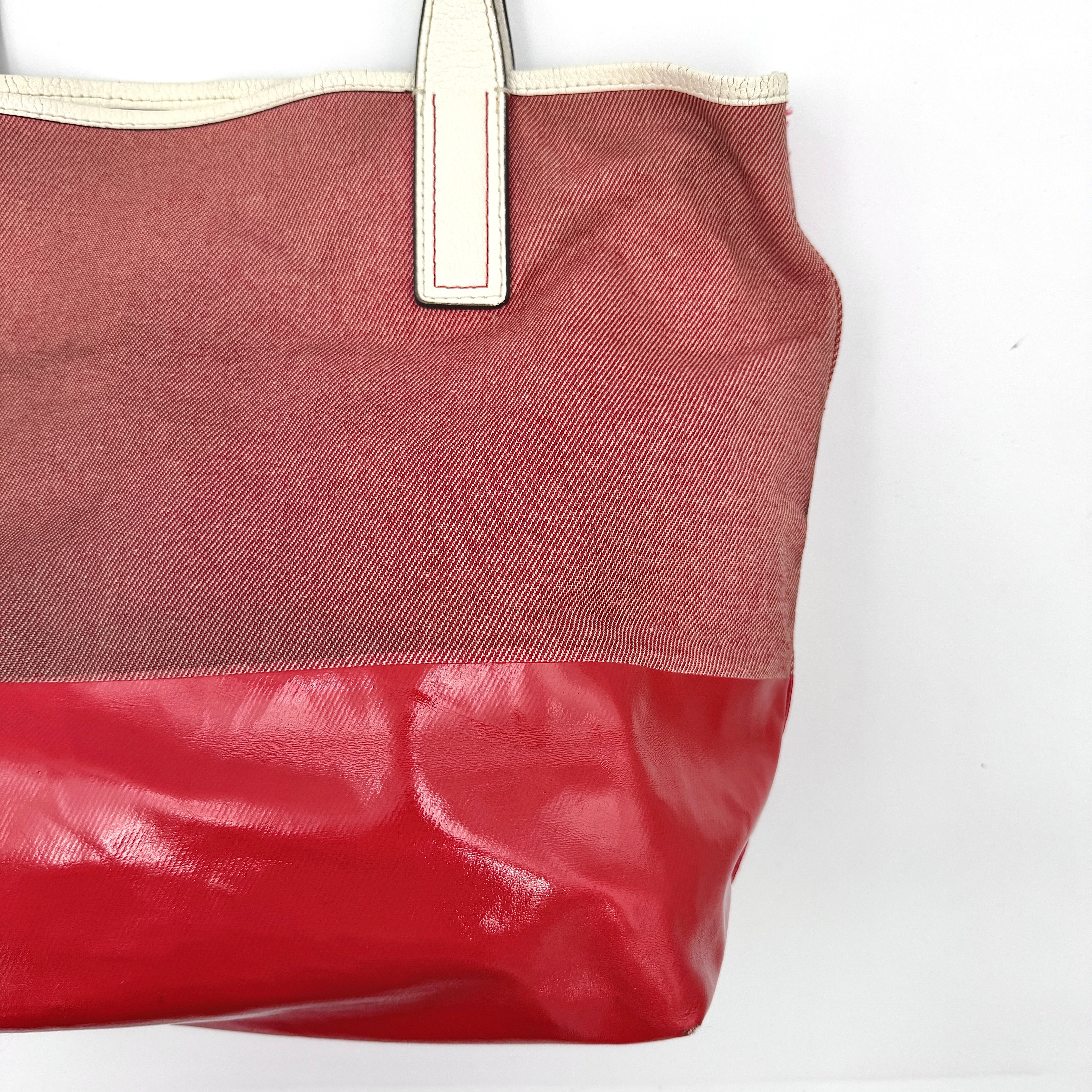Kate Spade Ash Street Logo Tote in red canvas with glossy red leather base and ivory handles, shown against a white background.