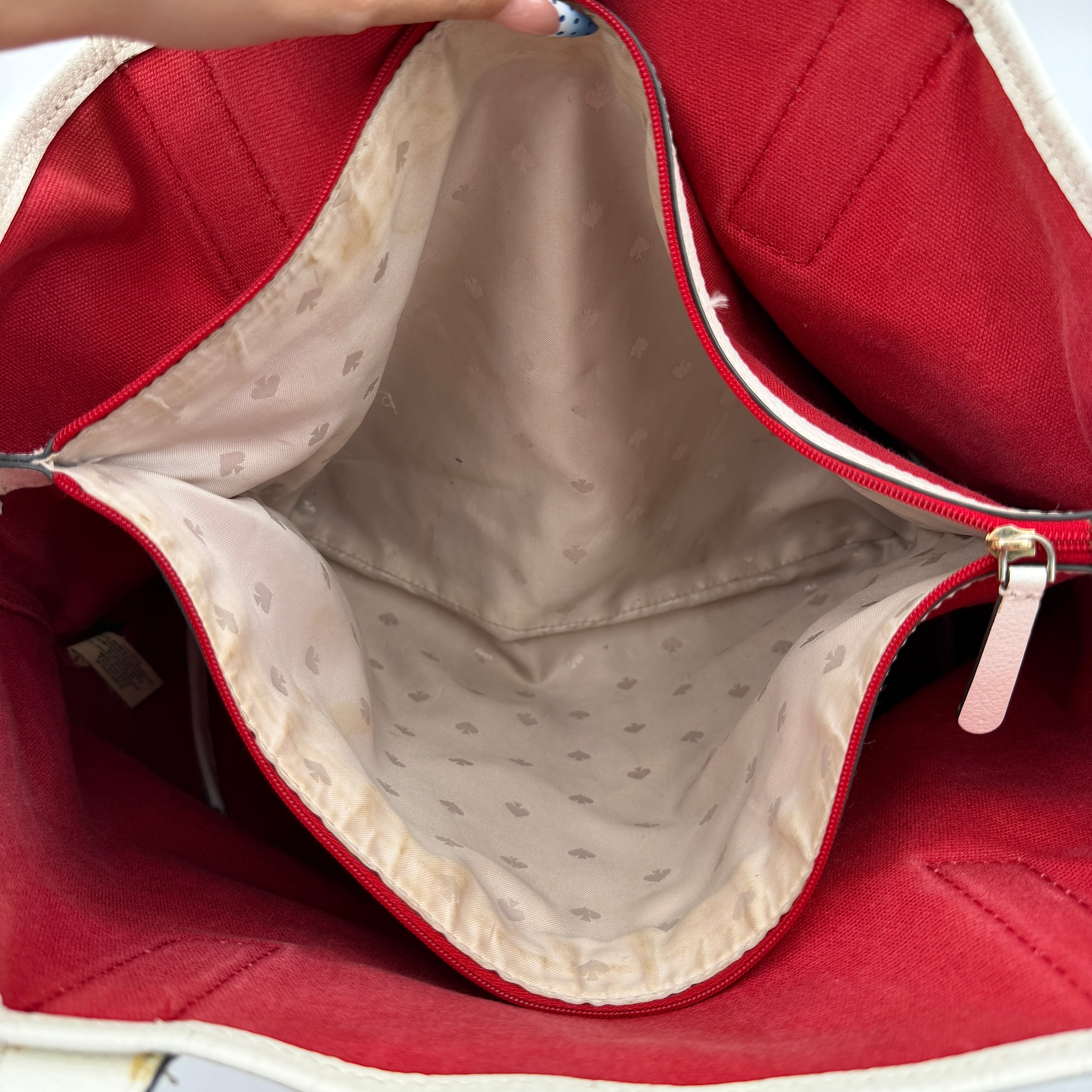 Kate Spade Ash Street Logo Tote in red canvas with glossy red leather base and ivory handles, shown against a white background.