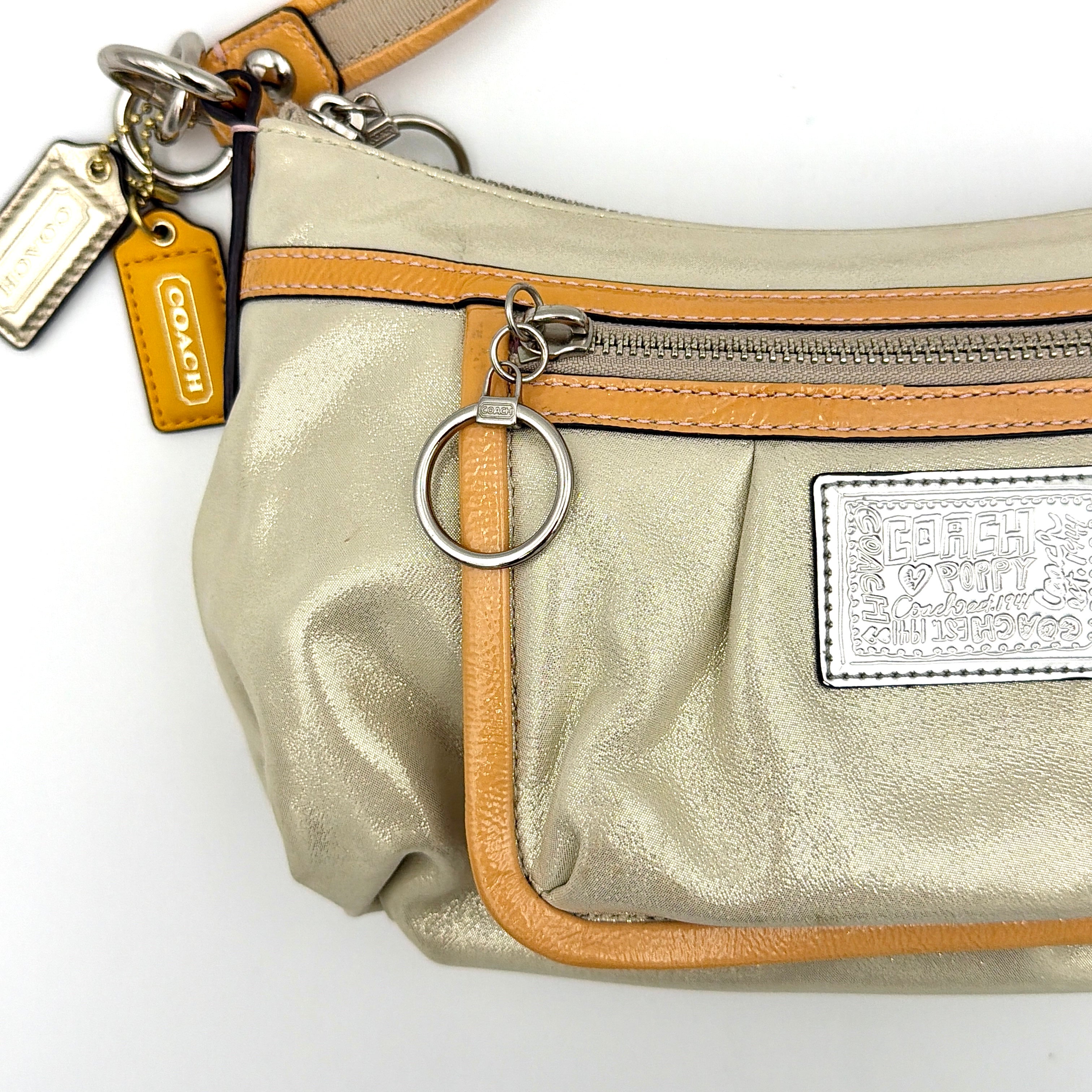 Coach Poppy Sparkle Groovy bag in cream with tan trim, metallic plaque, and detachable shoulder strap displayed alongside.