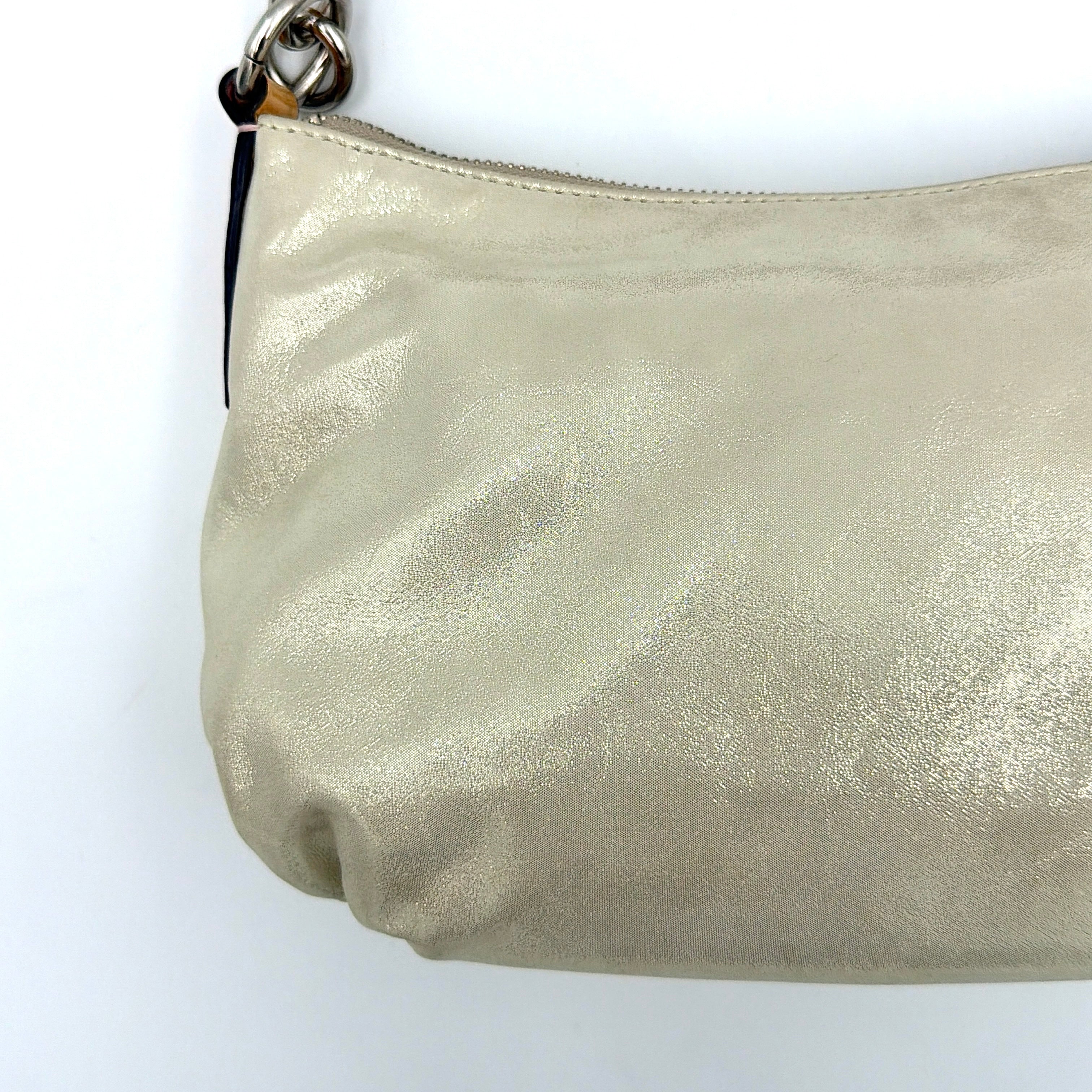 Coach Poppy Sparkle Groovy bag in cream with tan trim, metallic plaque, and detachable shoulder strap displayed alongside.