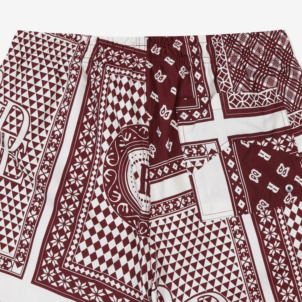 Rhude maroon and white swim shorts with a card print pattern and yellow drawstring, presented flat.