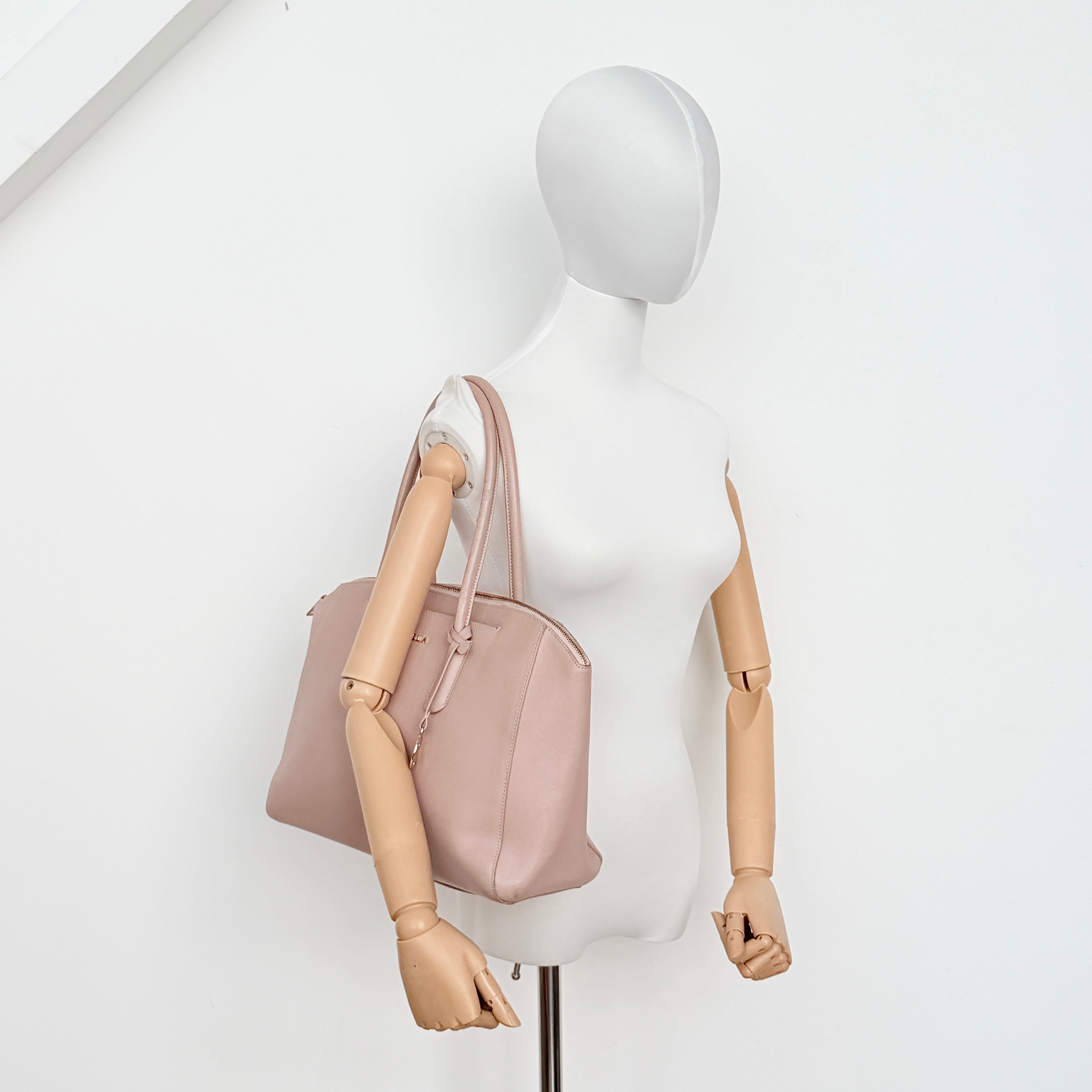 Furla Tessa handbag in light pink leather with gold hardware and double top handles.