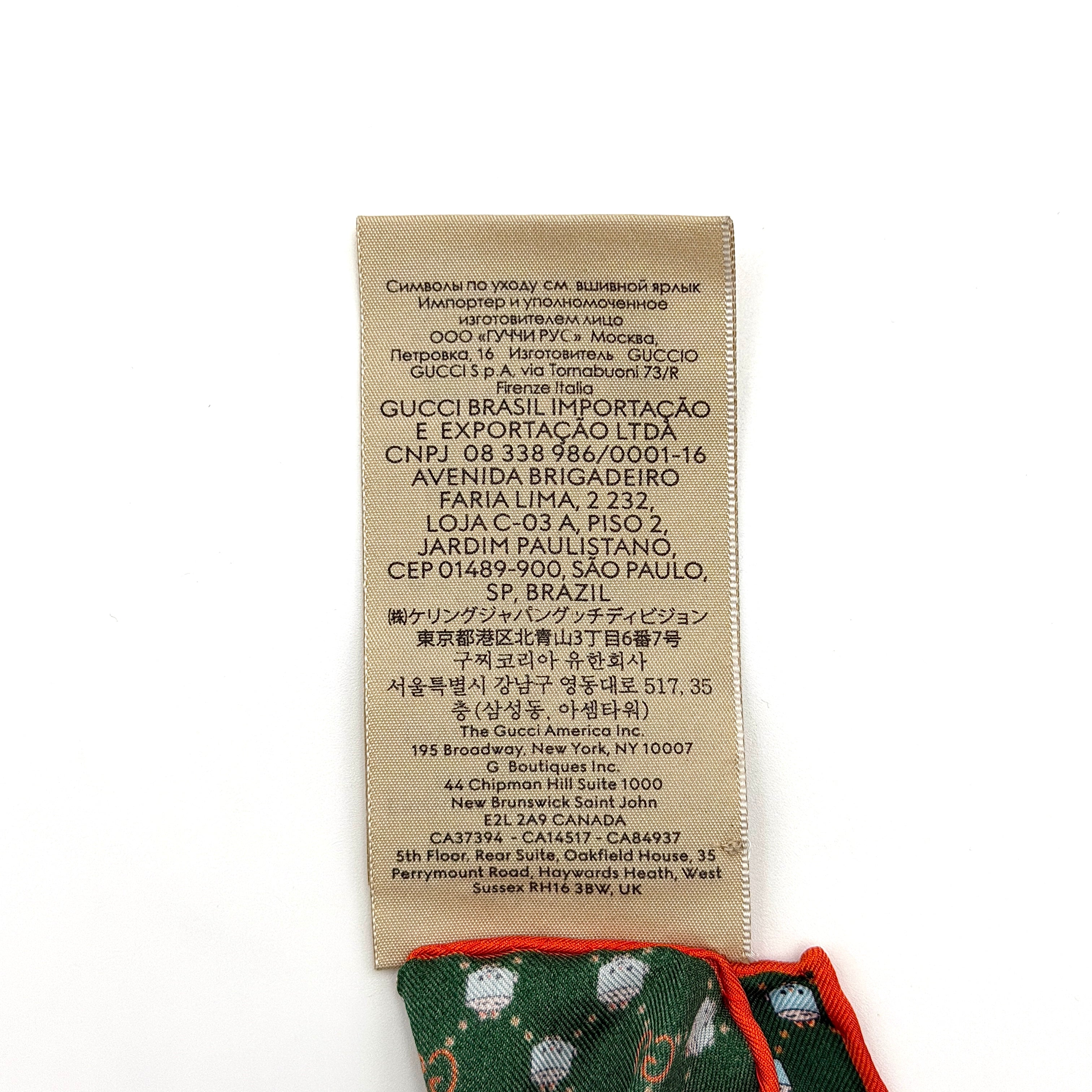 Gucci GG Monogram Silk Scarf in green silk, featuring a playful allover GG pattern and orange rolled edge.
