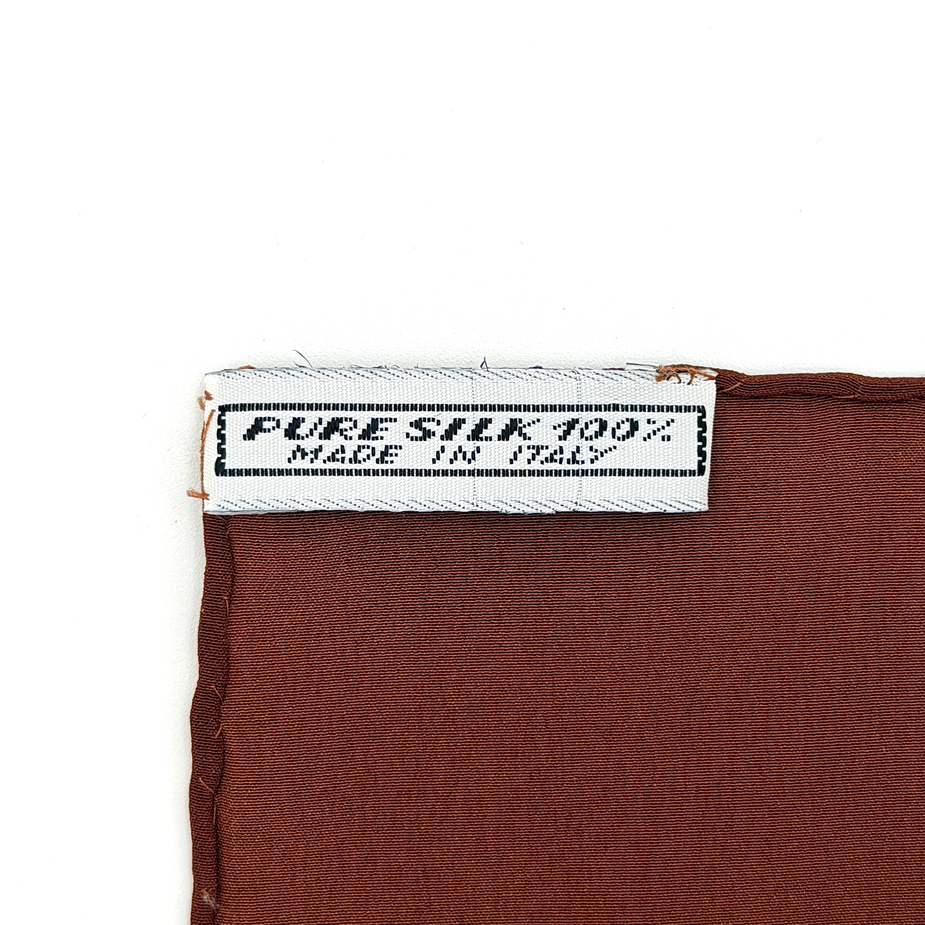 Celine silk scarf in raspberry pink, periwinkle blue, and brown with illustrated buckle and strap motifs.
