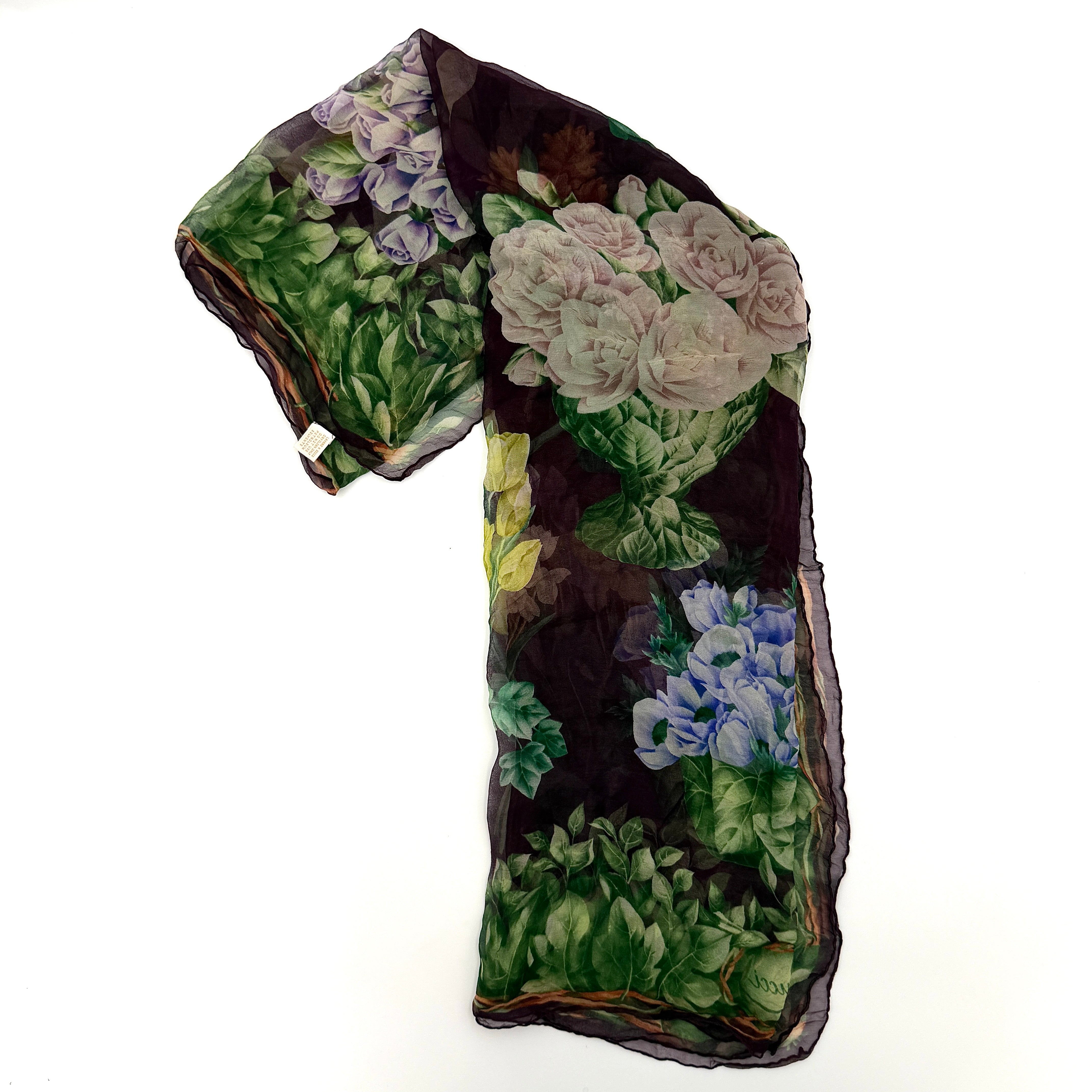 Gucci silk scarf adorned with artistic multicolour floral bouquets and leafy green border, elegantly draped to showcase its lightweight, sheer texture.