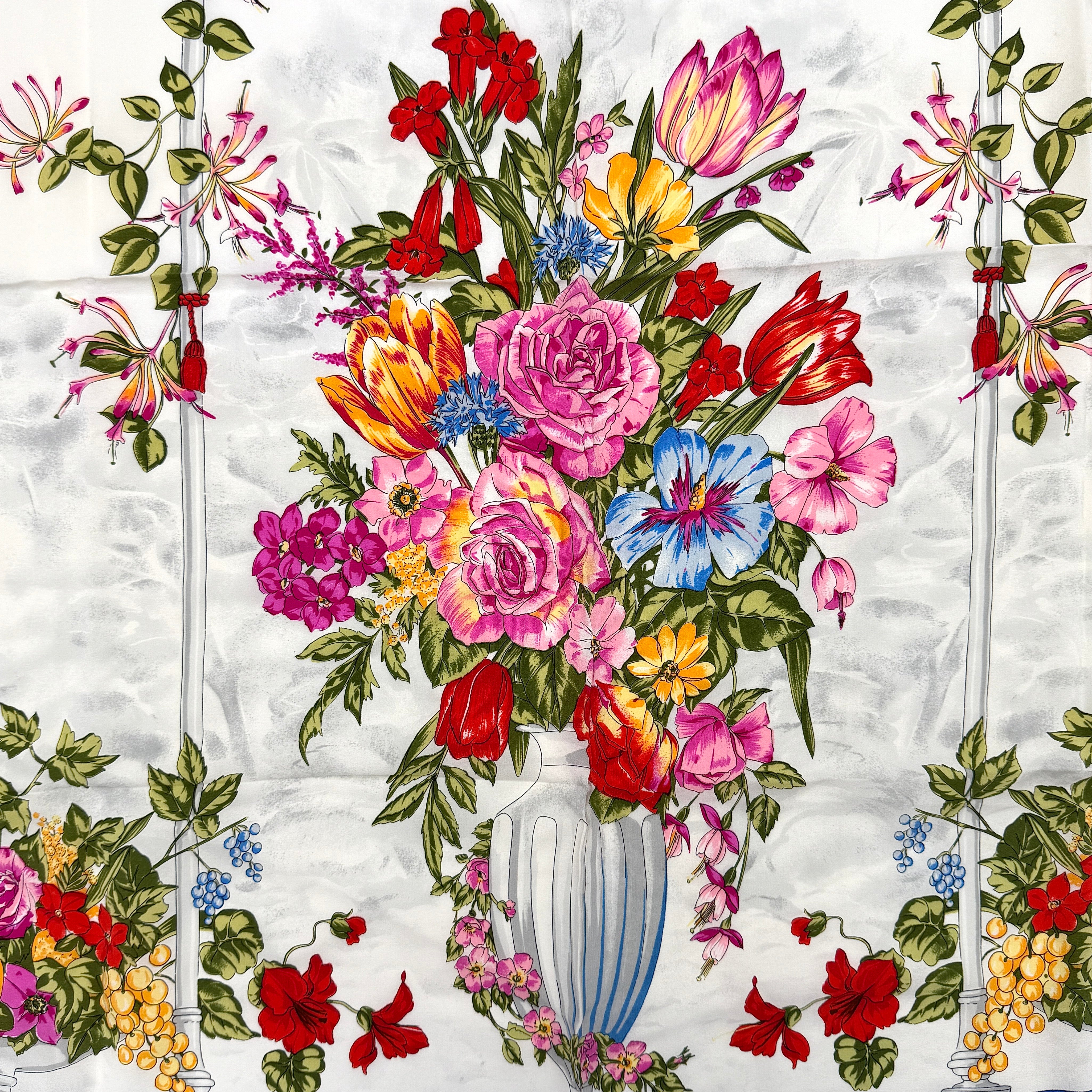 Dior silk scarf featuring an ornate multicolour floral print with a deep blue border.