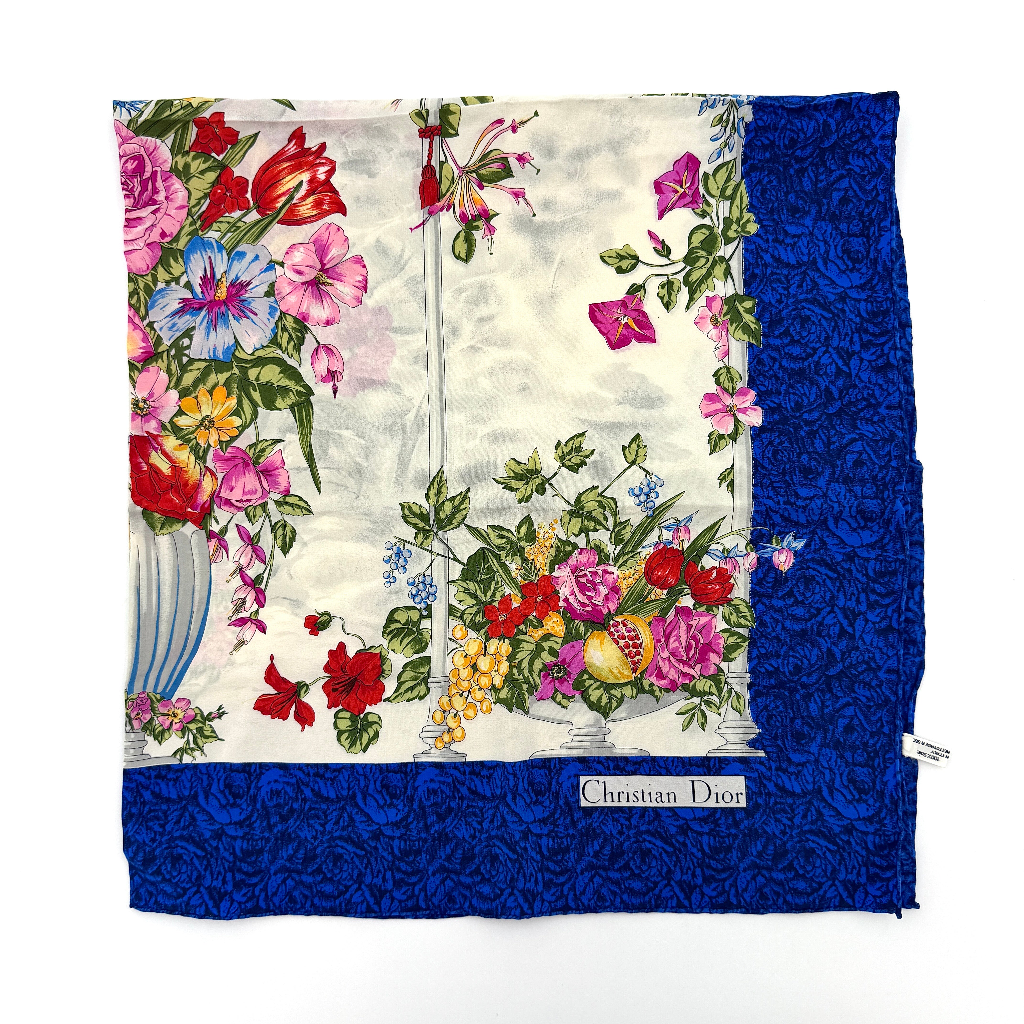 Dior silk scarf featuring an ornate multicolour floral print with a deep blue border.
