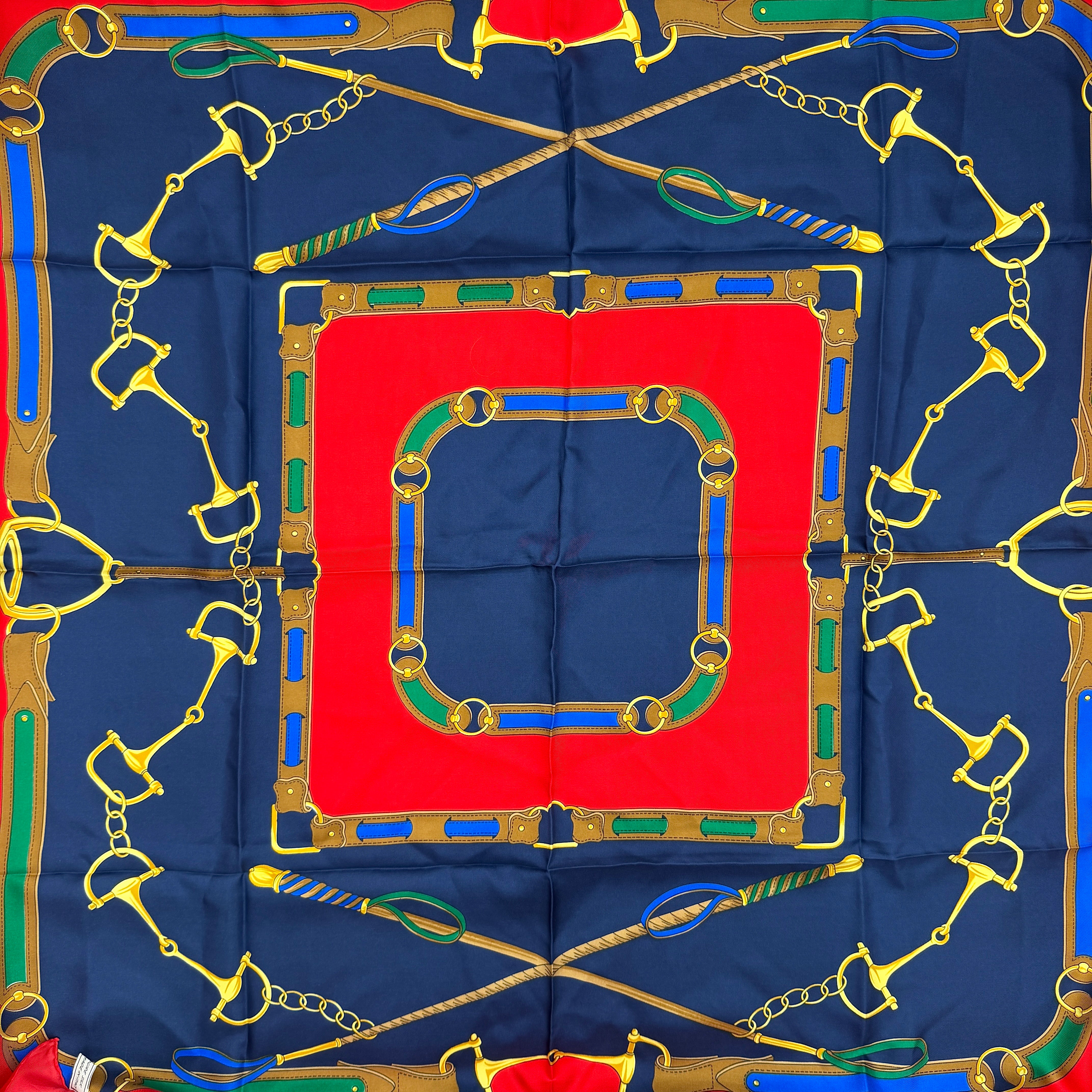 Celine silk scarf featuring a bold equestrian motif in navy, red, green, and gold.