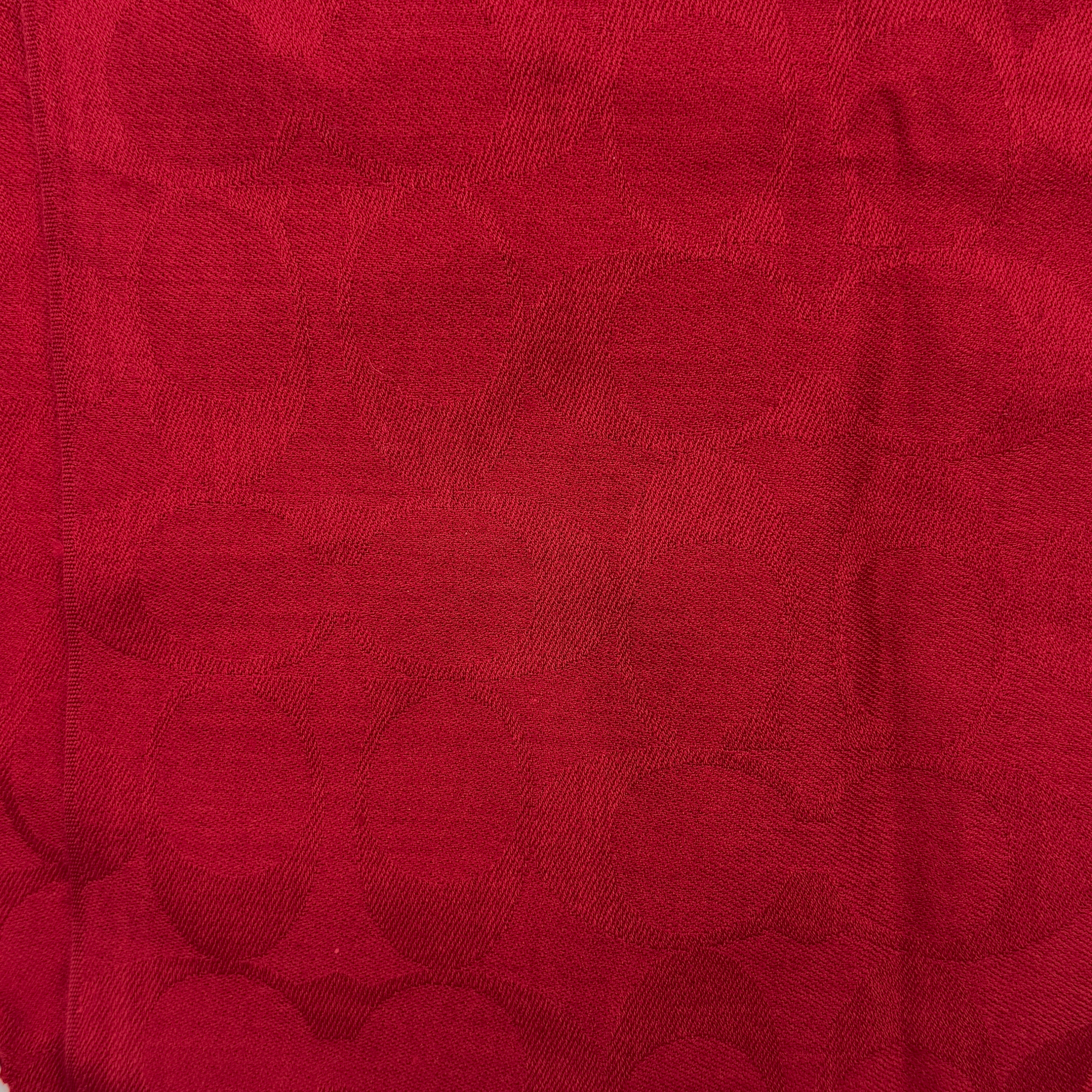 Coach Signature Monogram Wool Scarf in vibrant red wool and silk with tonal logo pattern and delicate fringe edging.
