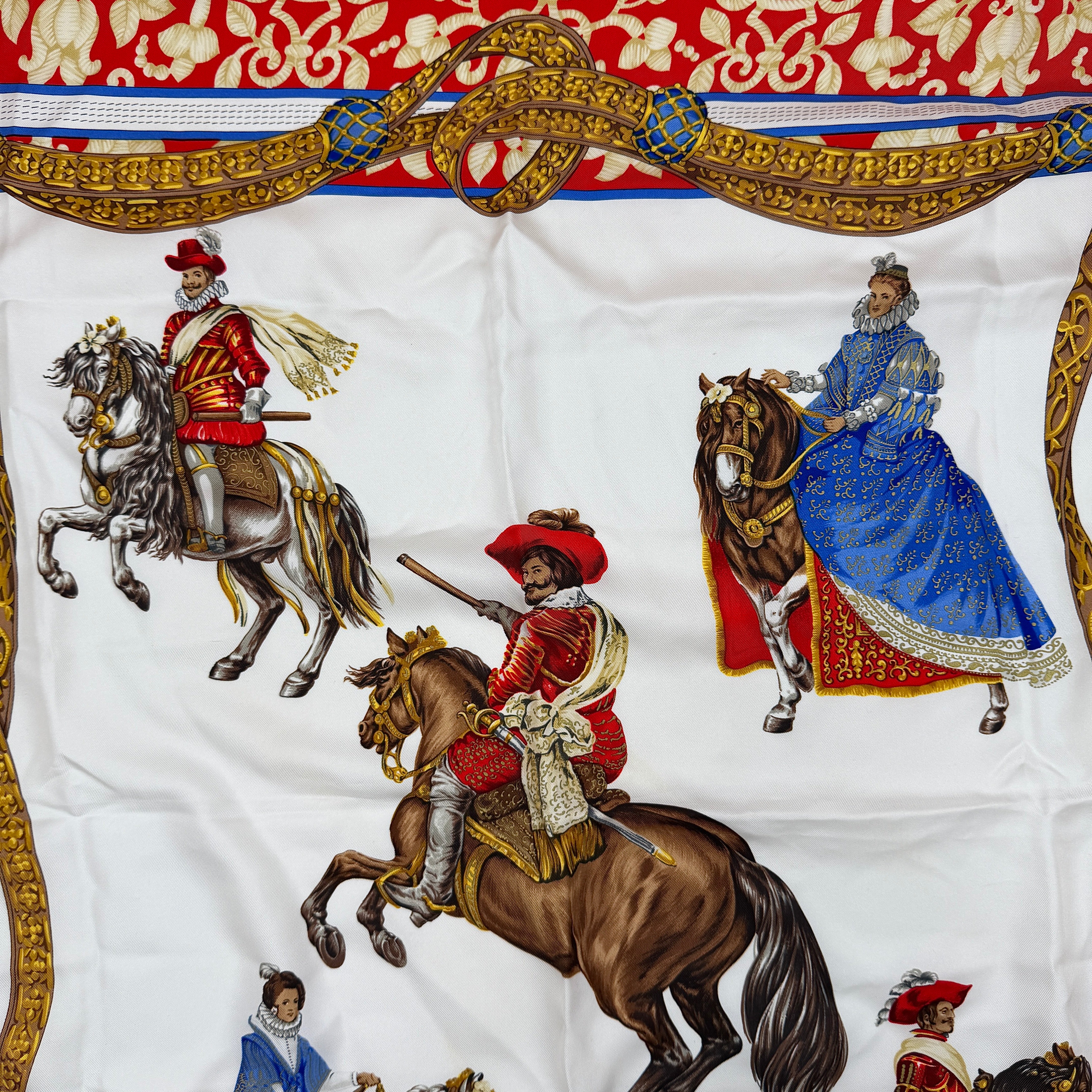 Loewe Velazquez Ecuestre silk scarf adorned with ornate red and gold baroque motifs and equestrian figures in rich multicolor.