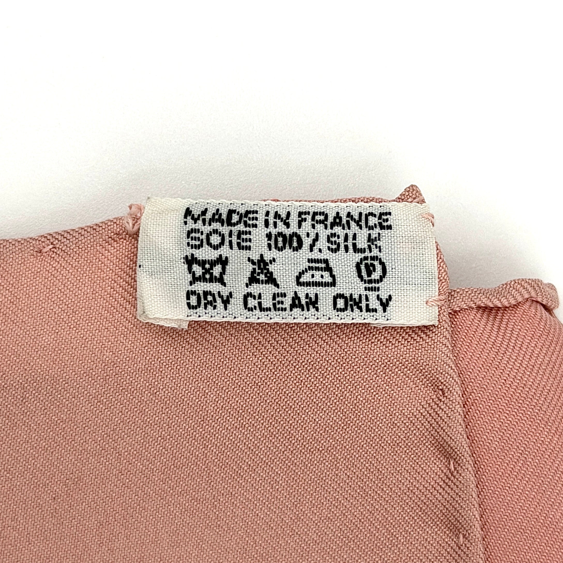Hermès Ombrelles et Parapluies silk scarf in pink with umbrella print and illustrated figures, gracefully draped to show the intricate design.
