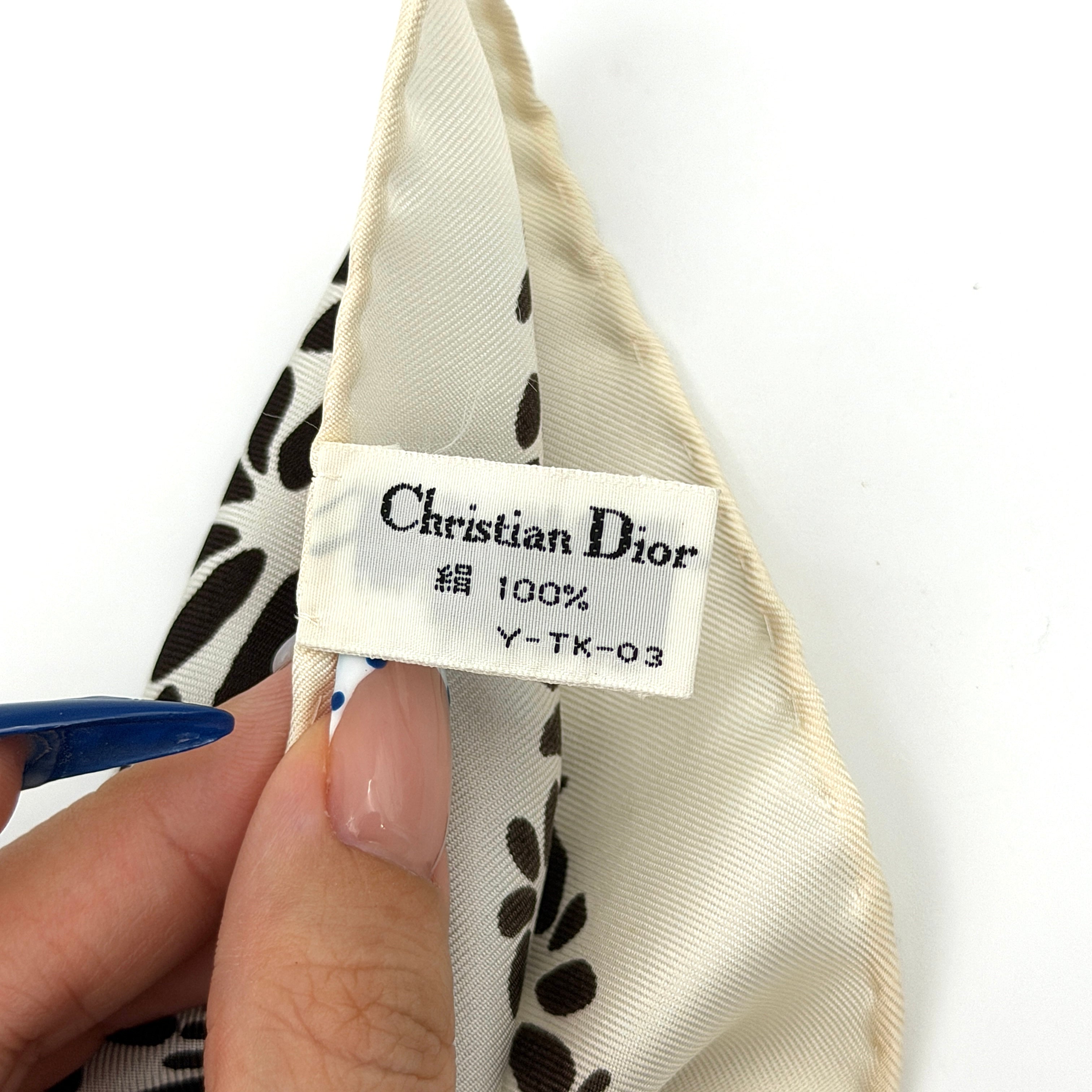 Dior silk scarf featuring a bold multicolor geometric floral pattern in red, blue, black, and ivory with the Christian Dior logo visible at the corner.