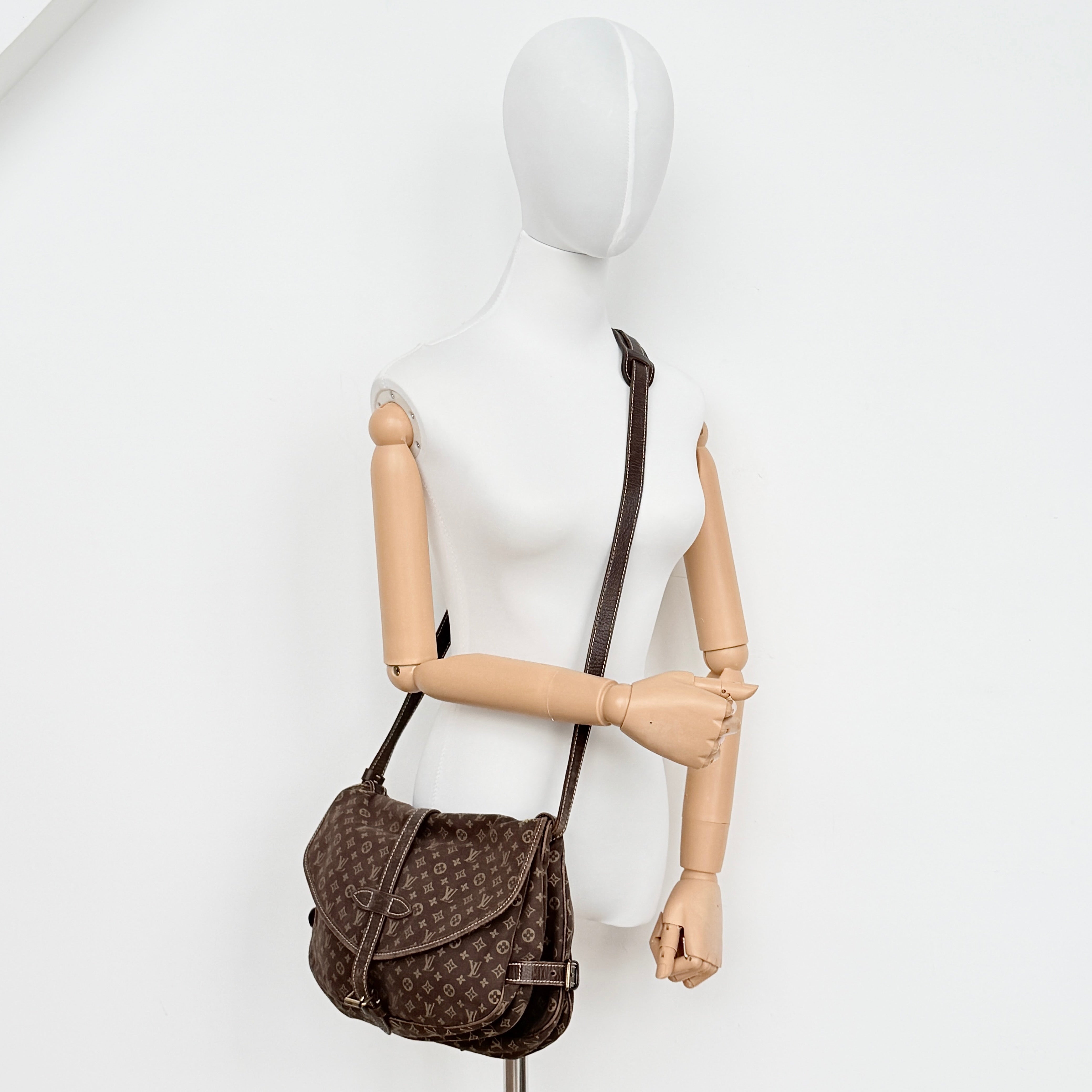 Louis Vuitton Monogram Mini Lin Saumur 30 in brown canvas with monogram pattern and leather buckled strap, photographed with the crossbody strap extended.