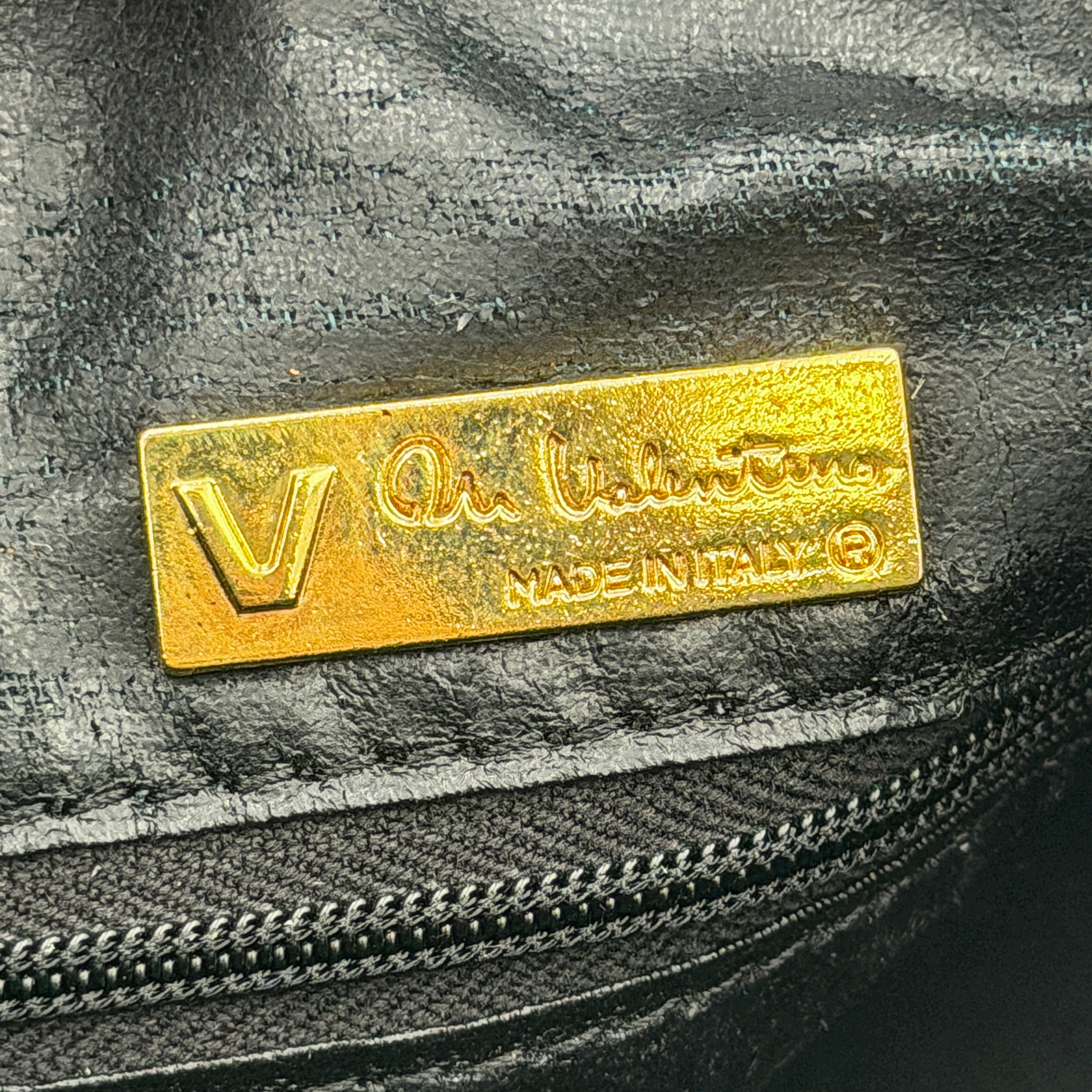 Valentino Monogram Boston Bag in black embossed leather with gold-tone V hardware and dual top handles.