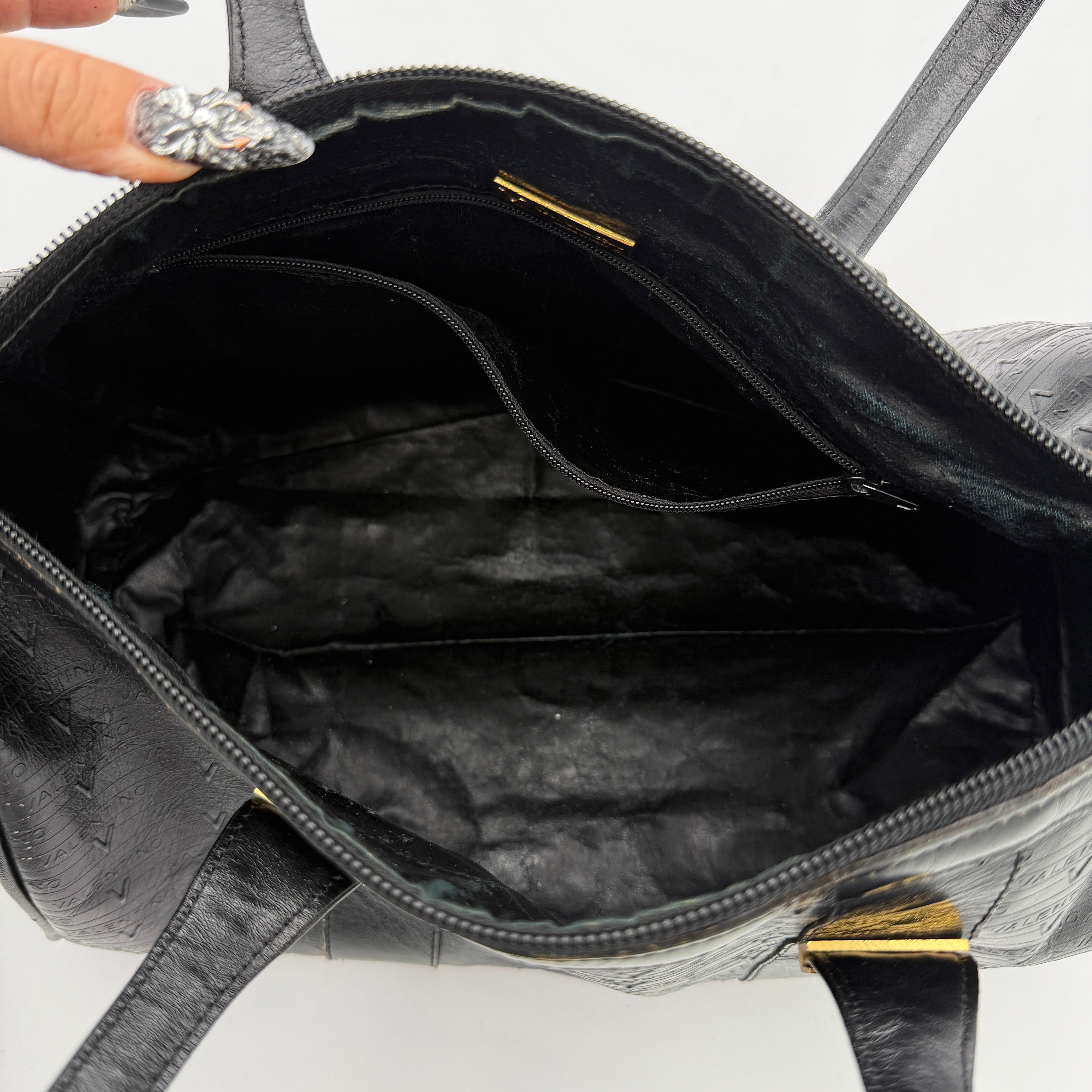 Valentino Monogram Boston Bag in black embossed leather with gold-tone V hardware and dual top handles.