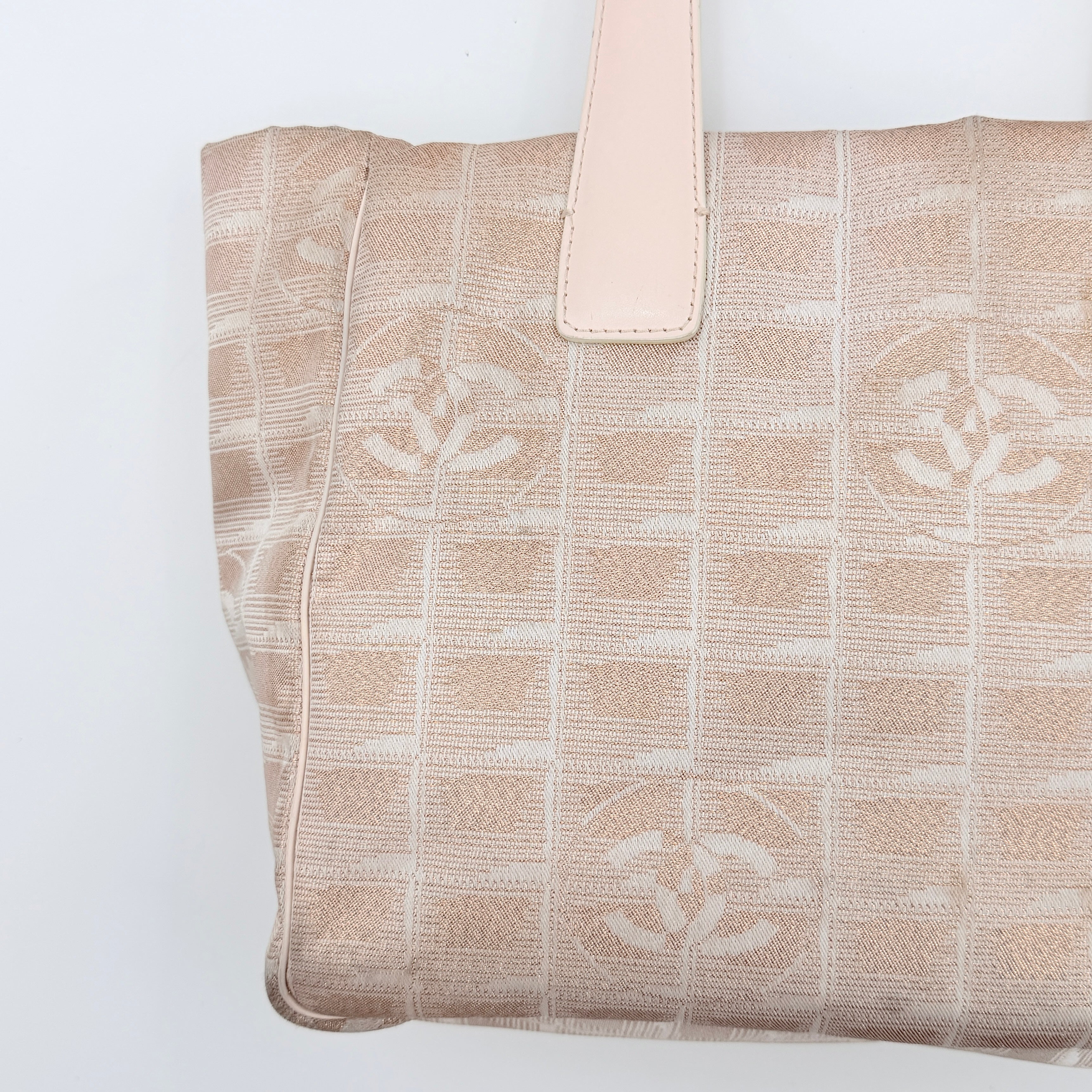 Chanel New Travel Line Tote Bag in rose gold jacquard with blush leather handles, displayed against a white background.